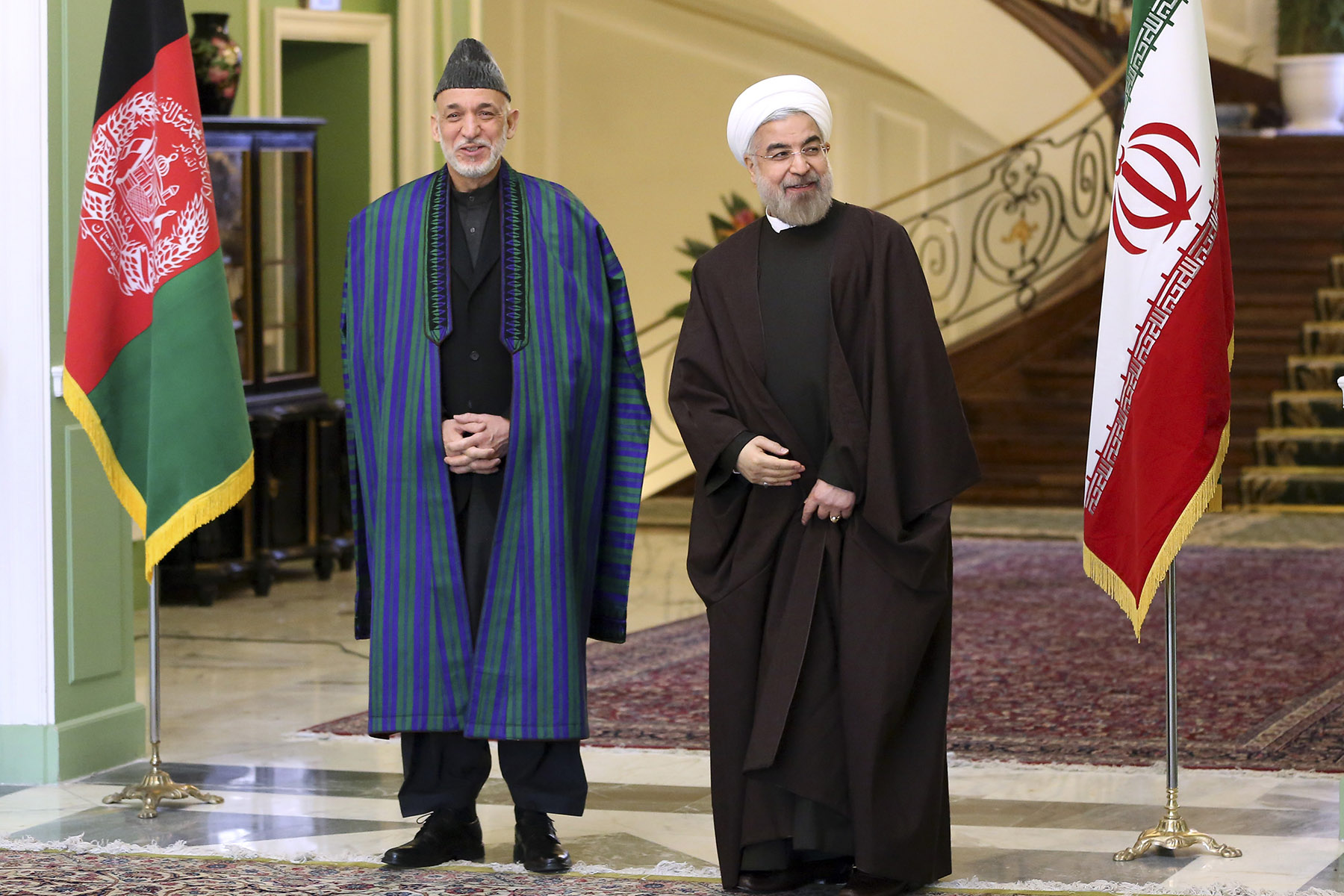 Iran's President Hassan Rouhani, right, stands with Afghan President Hamid Karzai, Sunday, Dec. 8, 2013. On Karzai’s watch, the Afghan economy has grown rapidly, at an average rate of 9.2% from 2003 to 2012. But only 27% of Afghans have access to safe drinking water, and 5% to adequate sanitation. (Ebrahim Noroozi / AP)
