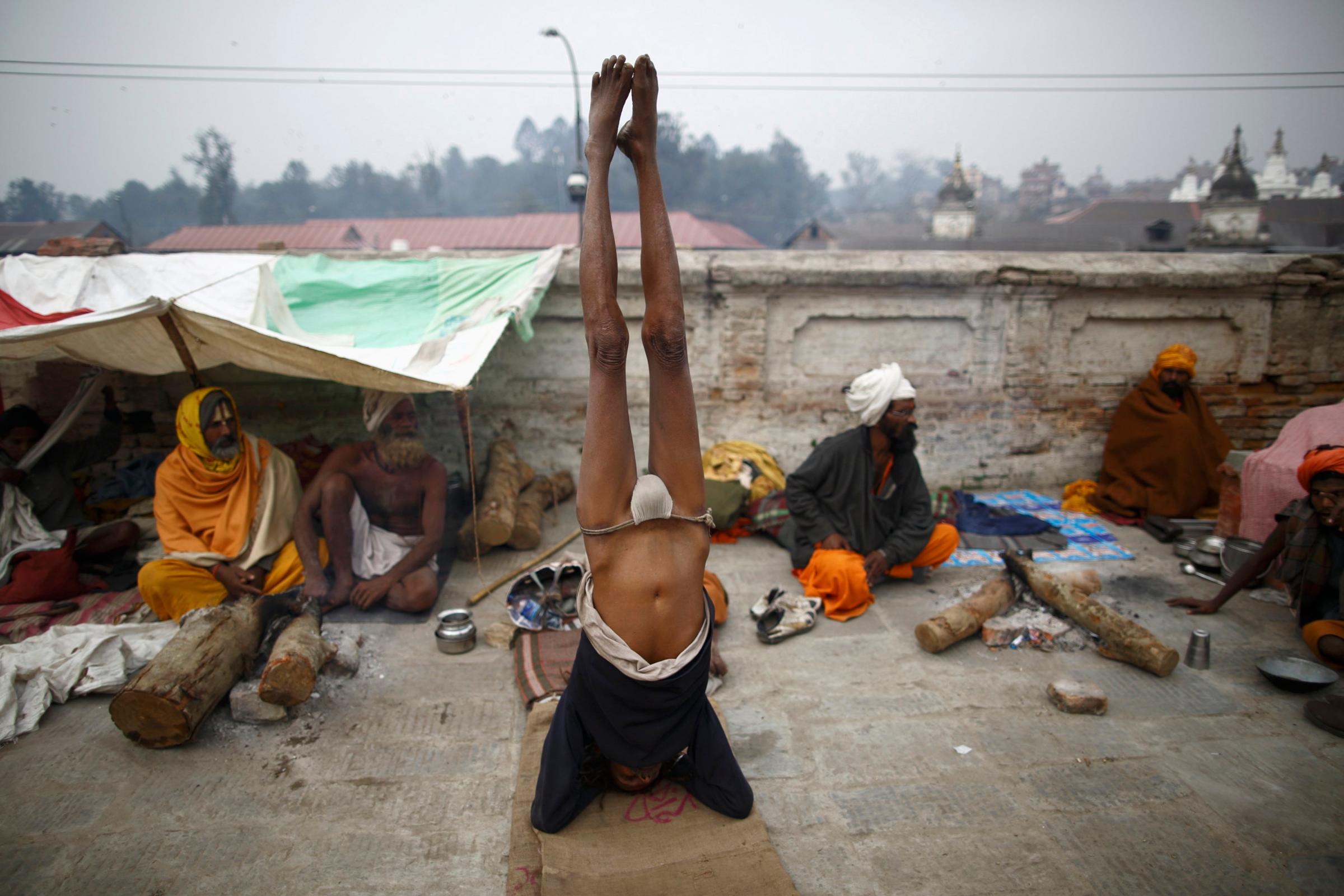 A Hindu holy man, or sadhu, performs yoga at the premises of Pashupatinath Temple in Kathmandu