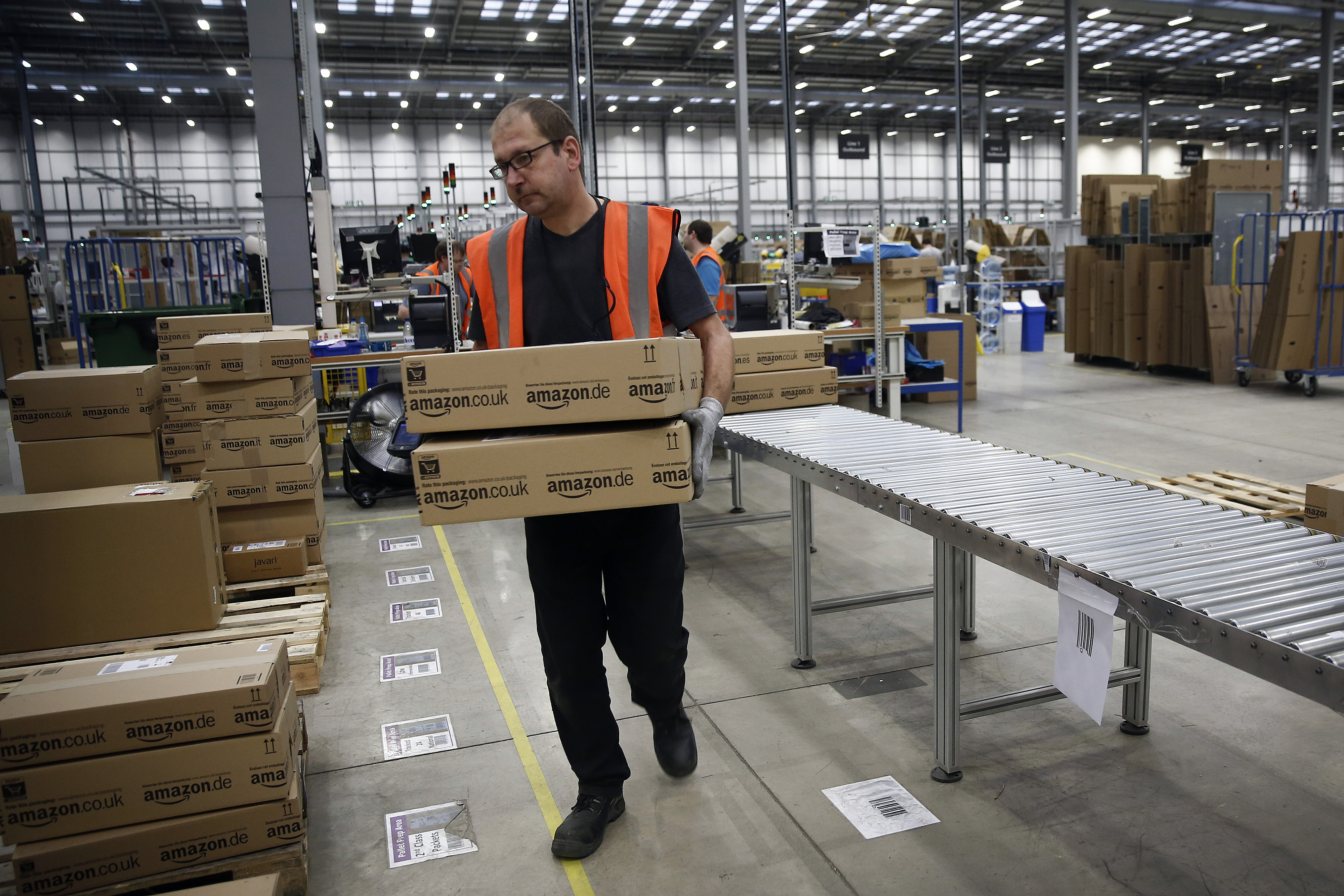 A employee sorts packaged customer orders ahead of shipping at one of Amazon.com Inc.'s fulfillment centers. (Bloomberg/Getty)