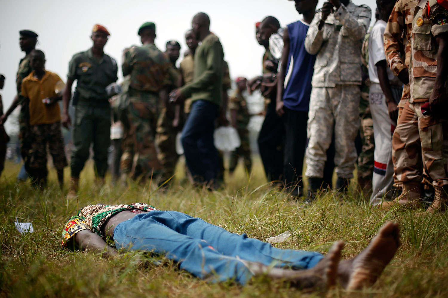 A man suspected to be a Muslim Seleka militiaman lays wounded after being stabbed by newly enlisted Central African Armed Forces soldiers moments after Central African Republic Interim President Catherine Samba-Panza addressed the troops in Bangui, Feb. 5, 2014.