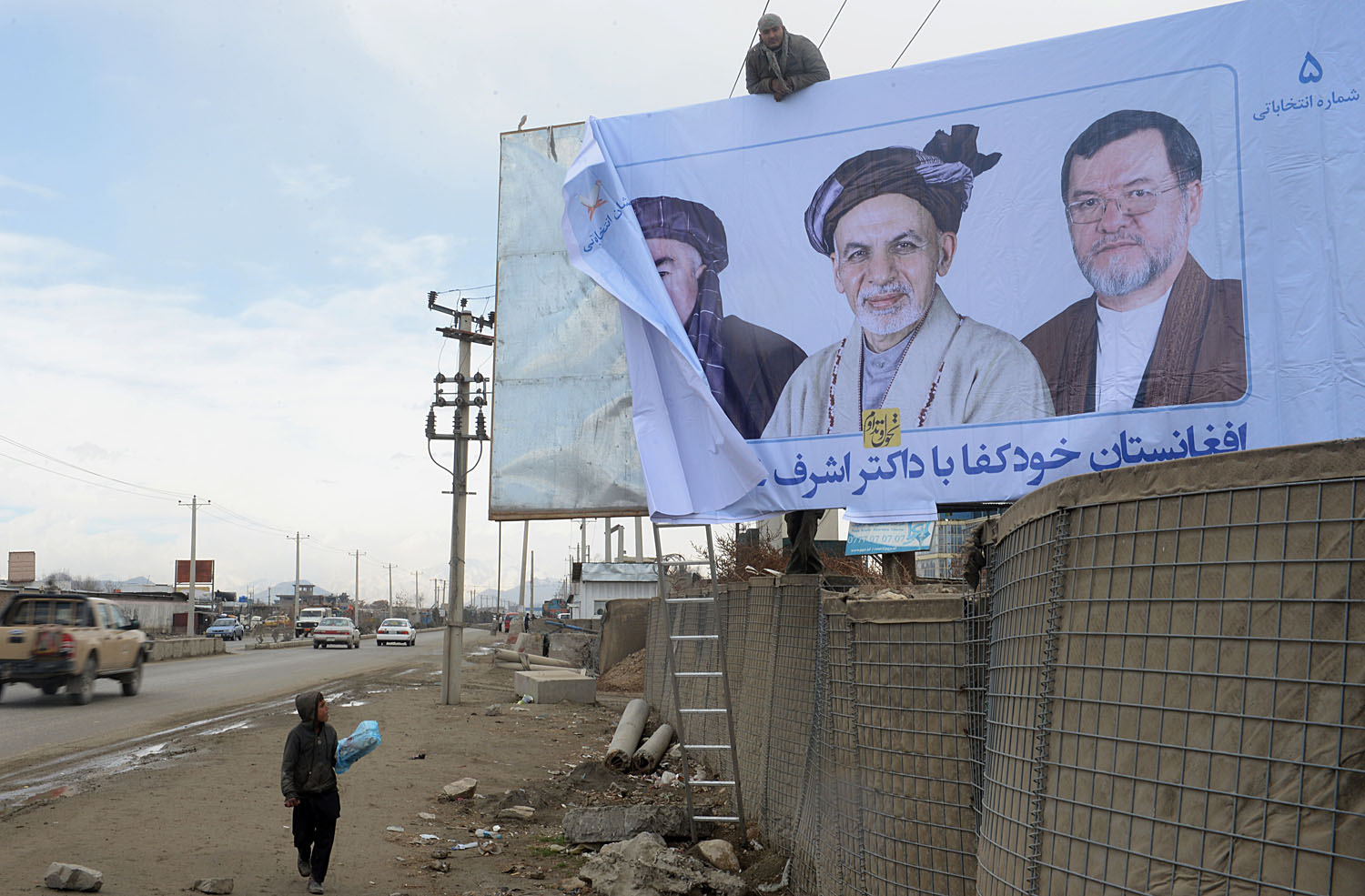 Afghan workers install an election campaign poster of Afghan presidential candidate Ashraf Ghani Ahmadzai in Kabul on Feb. 3, 2014. (Shah Marai&mdash;AFP/Getty Images)