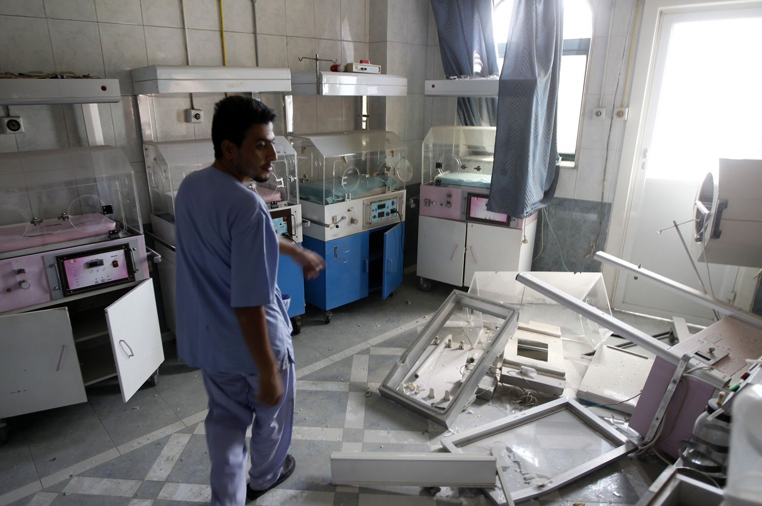 A man walks through a room at Dar Al Shifa Hospital, damaged in a Syrian Air force air strike the day before, in the Sha'aar neighborhood of Aleppo on Aug. 15, 2012.
