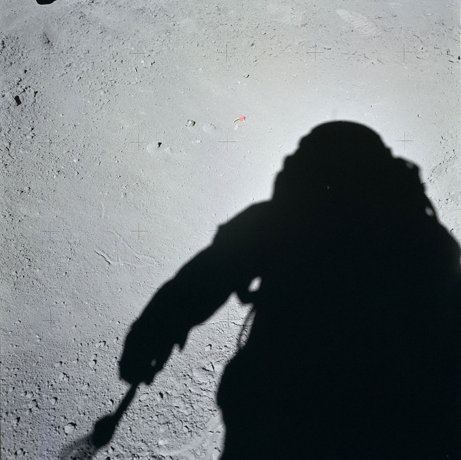 One of the most dramatic finds on Apollo 15 was the discovery of tiny glass spheres in the soil_mostly green-that were the remains of fiery meteorite impacts. This shadowy shot of Scott was taken just before he and Jim Irwin collected the first samples.