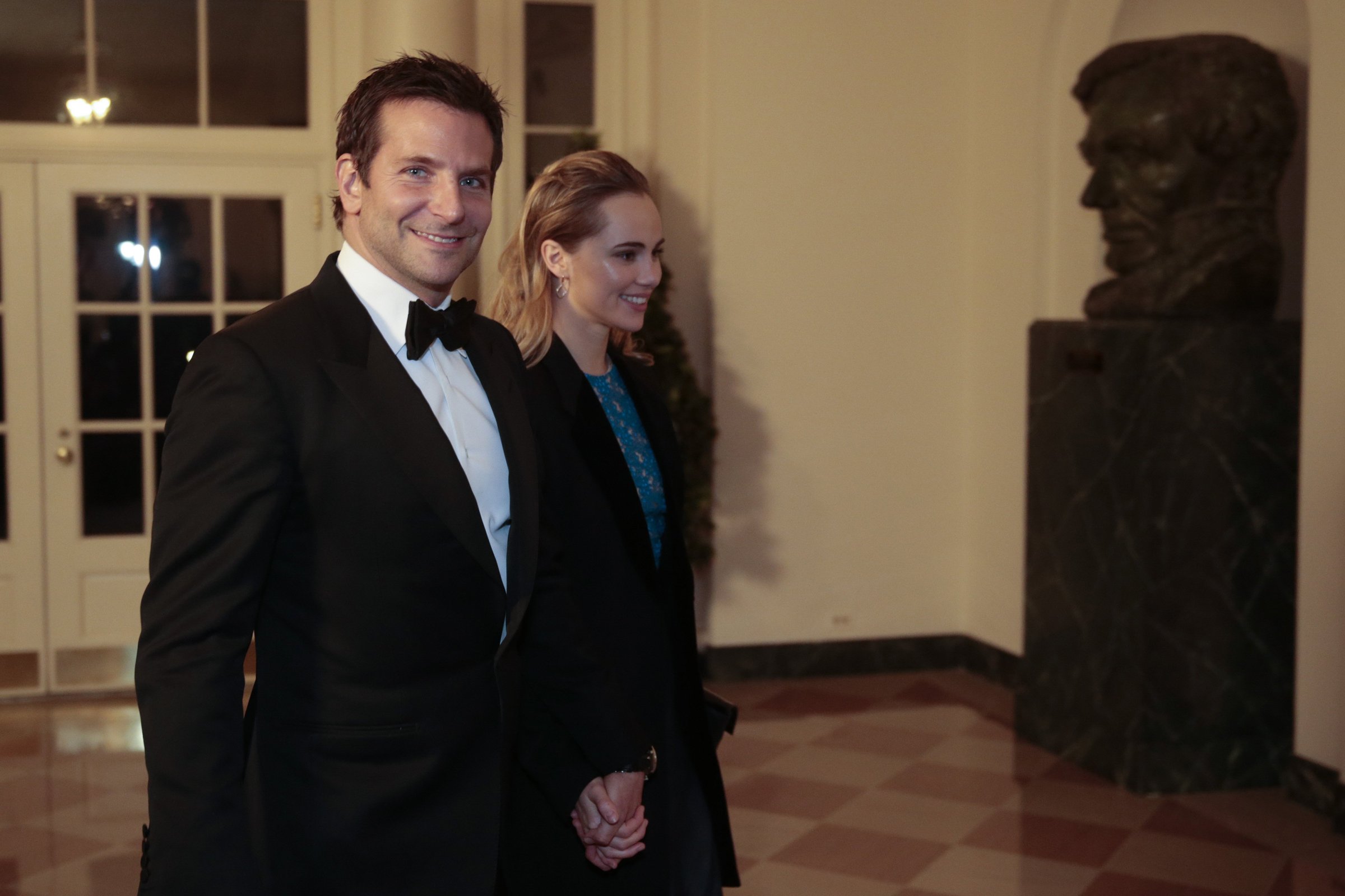 Actor Bradley Cooper, left, and Suki Waterhouse arrive to a state dinner hosted by U.S. President Barack Obama and U.S. first lady Michelle Obama in honor of French President Francois Hollande at the White House on February 11, 2014 in Washington.