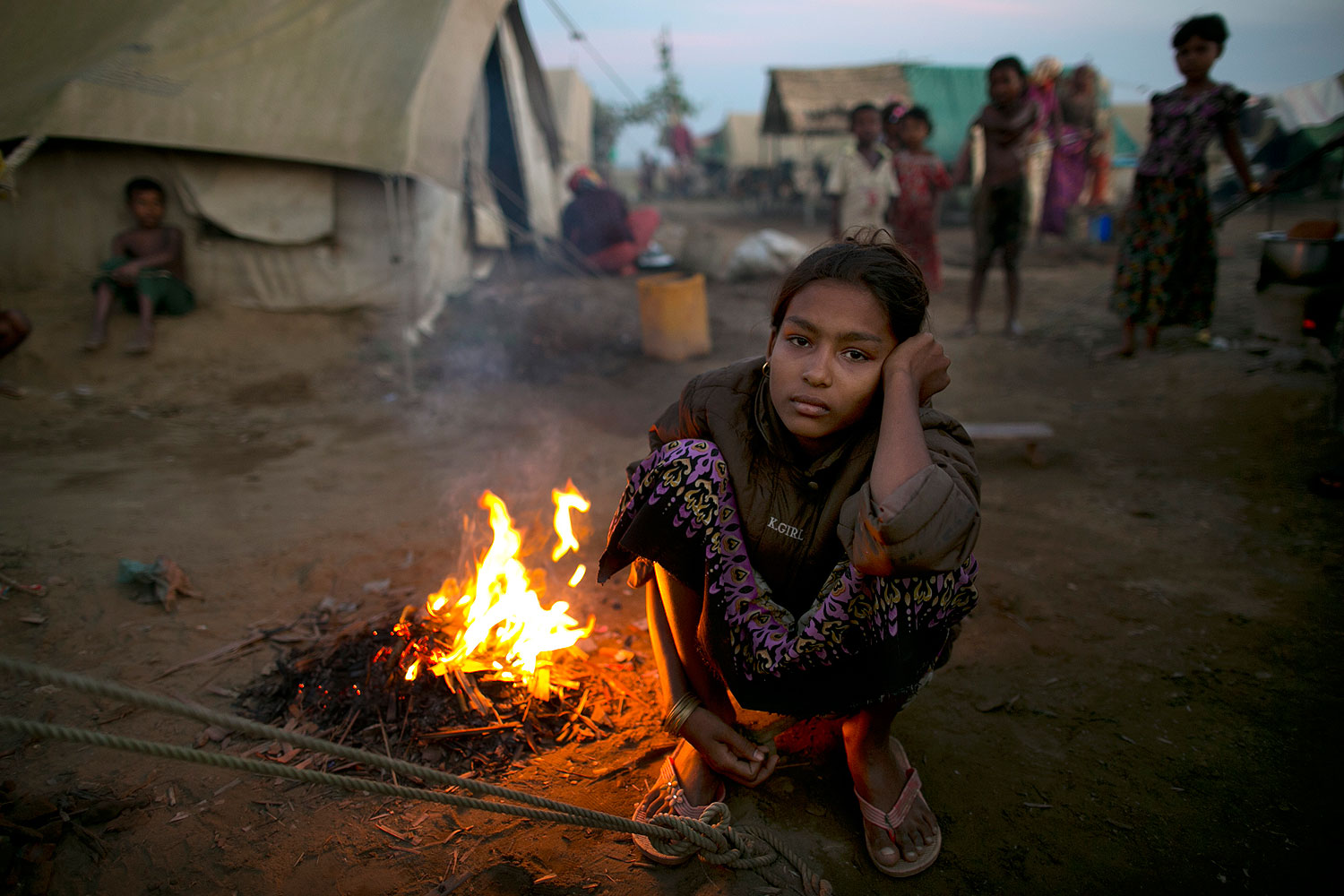 A Rohingya woman sits by a fire at a crowded internally displaced persons (IDP) camp Nov. 23, 2012 on the outskirts of Sittwe, Burma (Paula Bronstein / Getty Images)