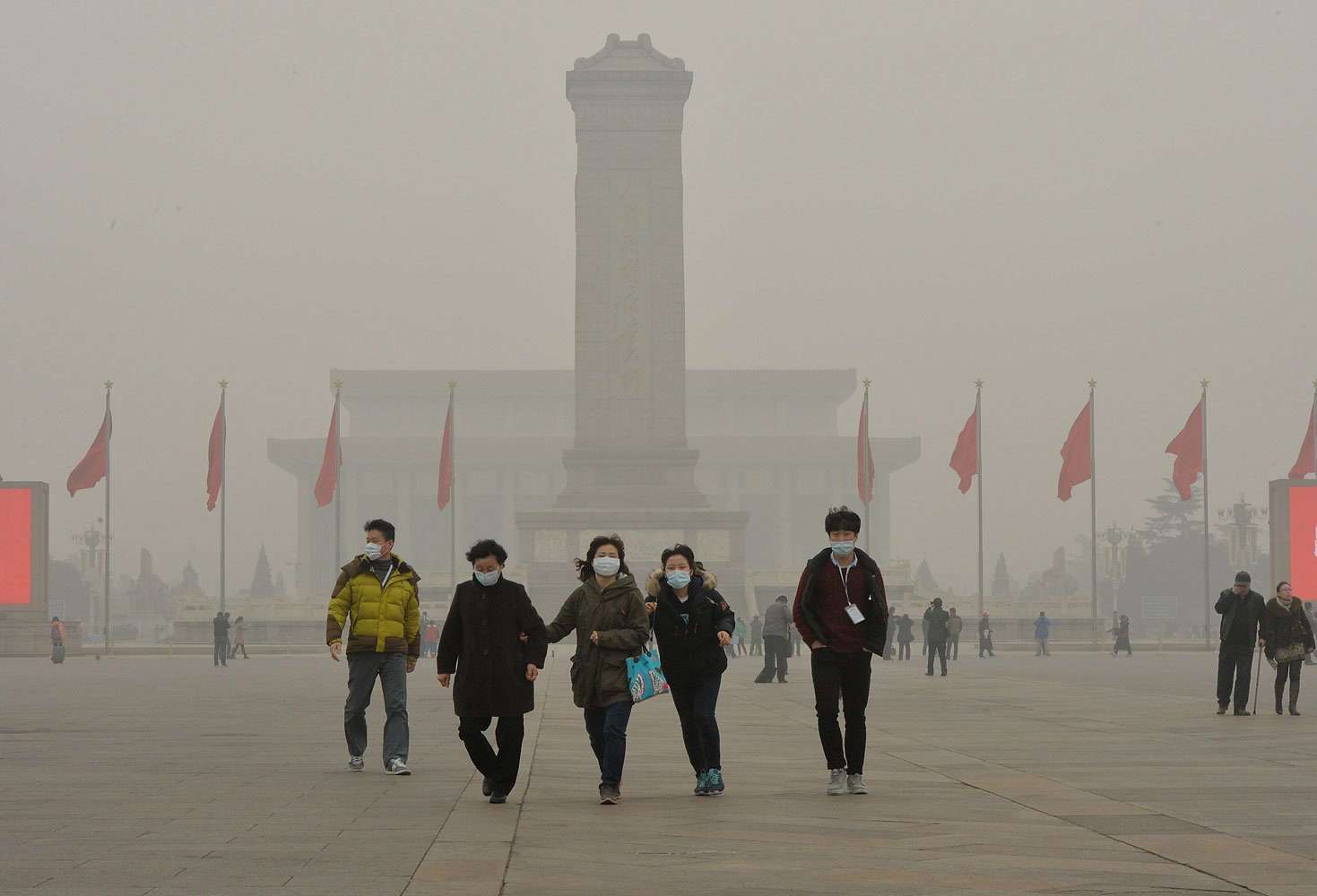 Chinese tourists wearing face masks visit Tiananmen Square as heavy air pollution continues to shroud Beijing on Feb. 26, 2014.