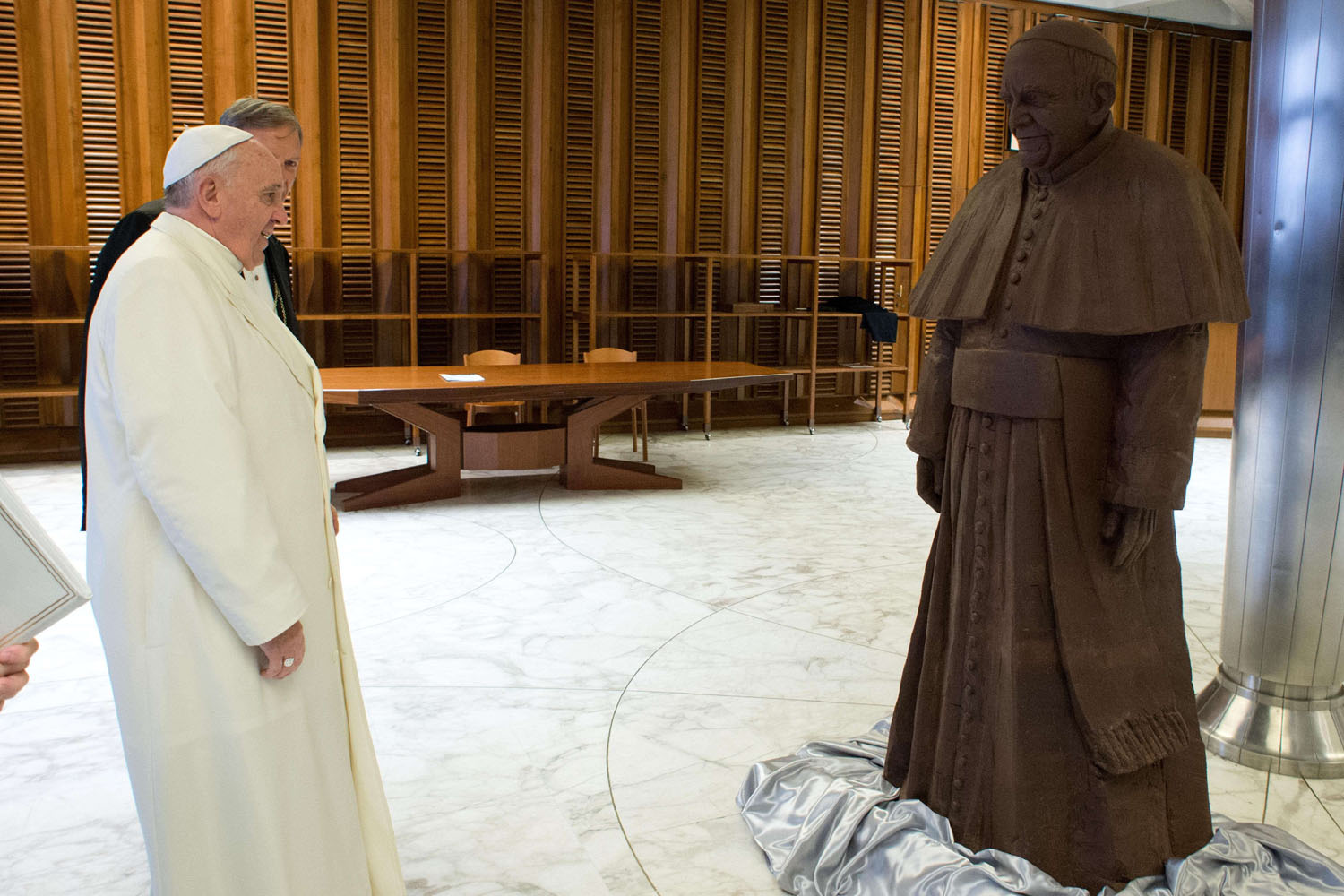 Pope Francis looks at a chocolate statue of himself, given to him after his weekly audience, on Feb. 5, 2014.