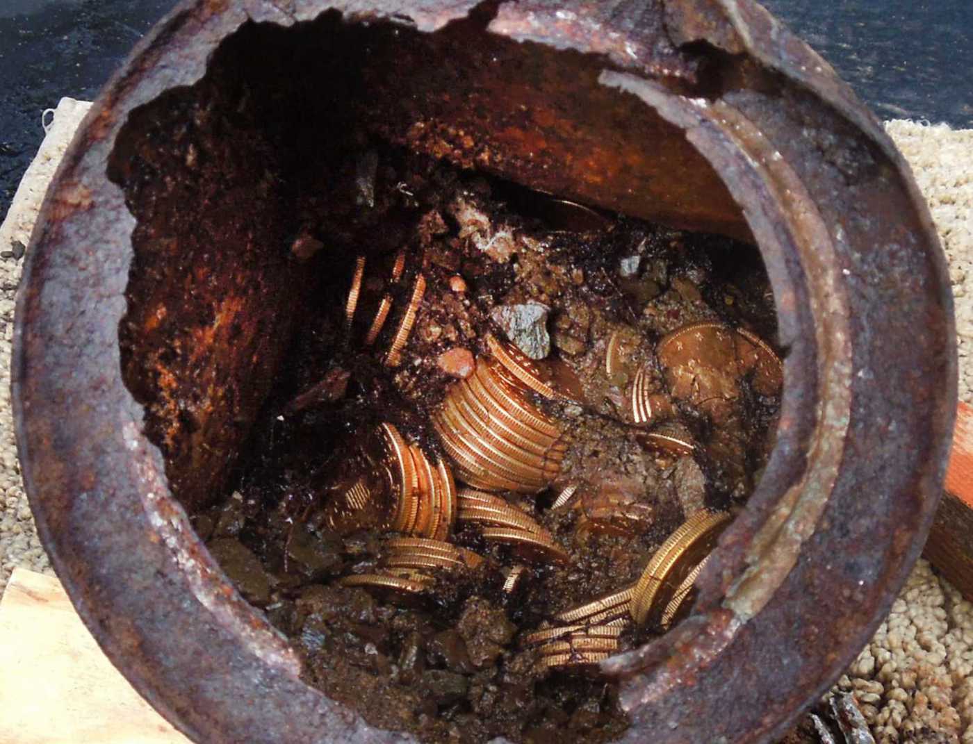 This image provided by the Saddle Ridge Hoard discoverers via Kagin's, Inc., shows one of the six decaying metal canisters filled with 1800s-era U.S. gold coins unearthed in California by two people who want to remain anonymous.
