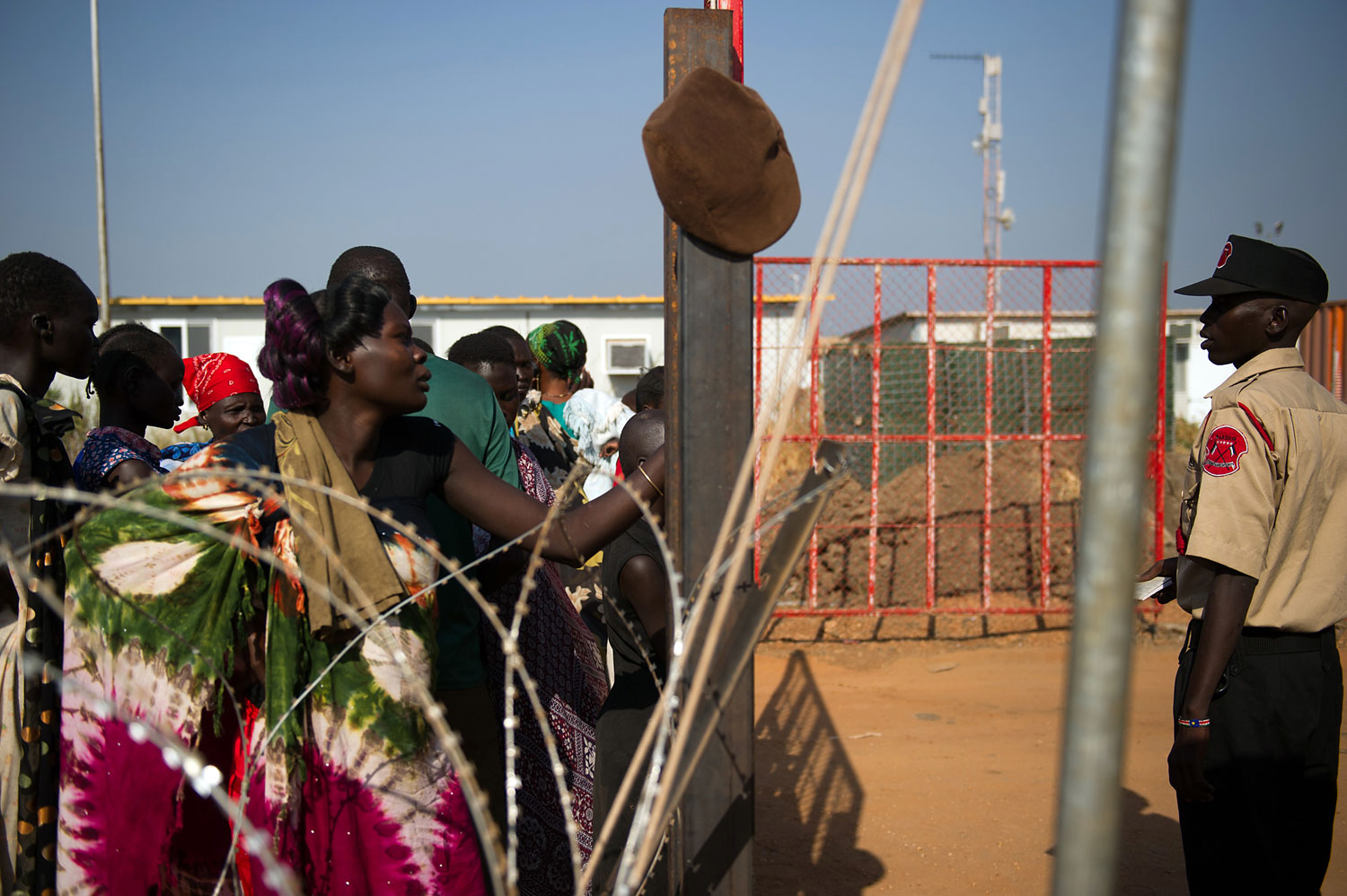 People stand at the gates of a spontaneous camp for internally displaced persons at the United Nations Mission to South Sudan base in Juba, South Sudan, on Jan. 9, 2014. Over 17,000 people are living at the base, with new arrivals every day, due to ongoing conflict in the world's youngest nation.