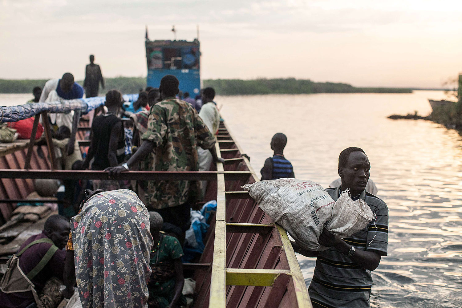People unload the few belongings on Jan. 9, 2014 at Minkammen, South Sudan that they were able to bring with them to the camps.