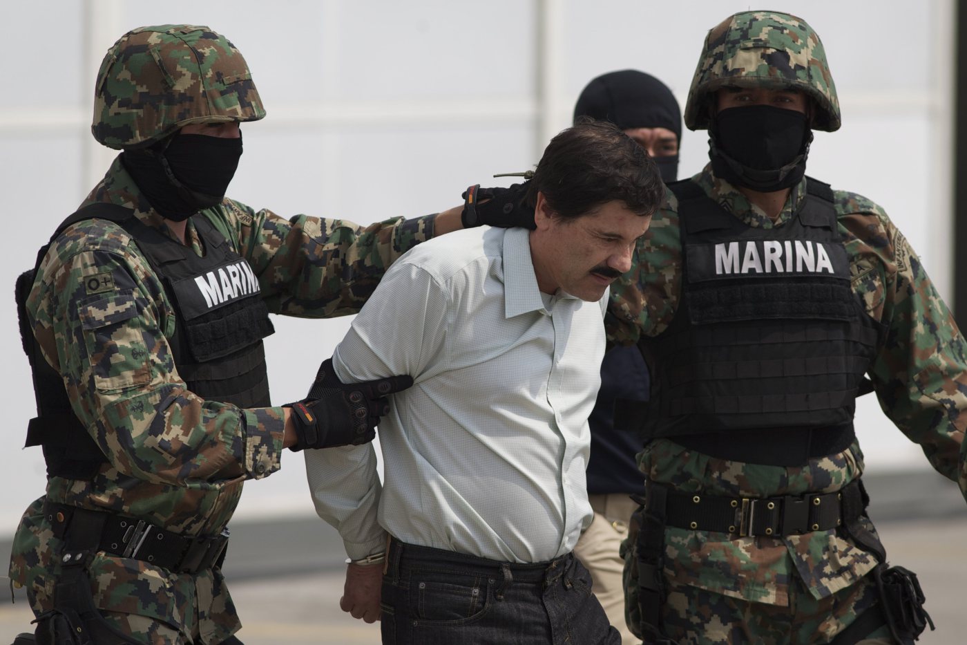Joaquin "El Chapo" Guzman is escorted to a helicopter in handcuffs by Mexican marines at a navy hanger in Mexico City, on Feb. 22, 2014.