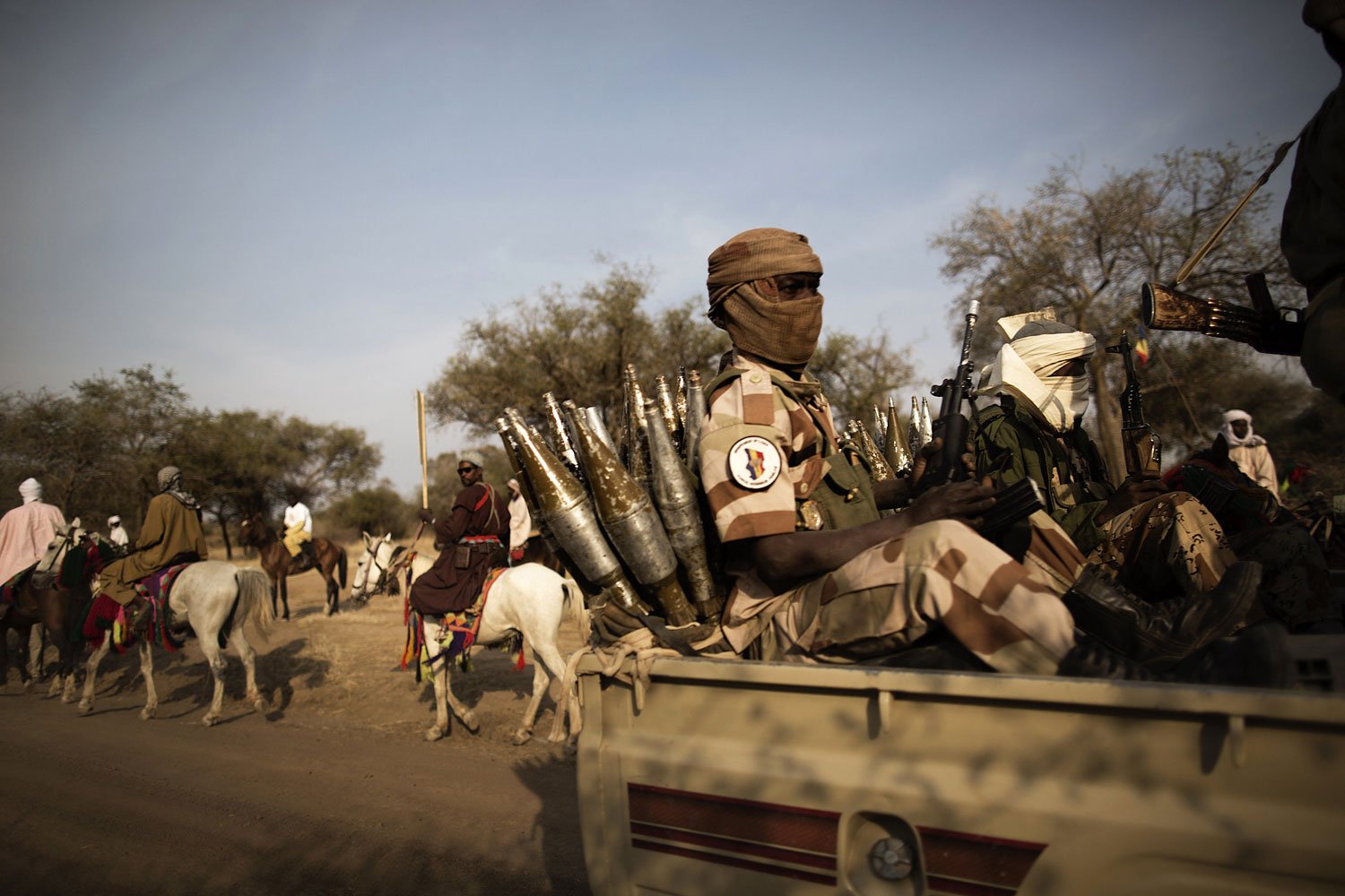 Chadian soldiers escorting the Chadian President, speed past horsemen arriving to attend a ceremony marking the 50th anniversary of the Zakouma National Park, Chad's oldest natural park, during which elephant tusks will be incinerated, Feb. 21, 2014.
