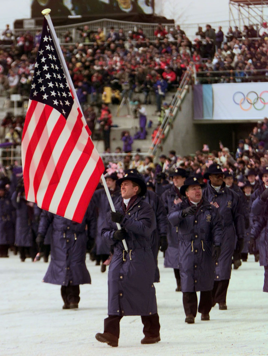 Four-time Olympic speed skater Eric Flaim carries the United States flag into the Olympic Stadium in Nagano, Japan, as he leads his team into the 1998 Winter Olympic Games opening ceremony.