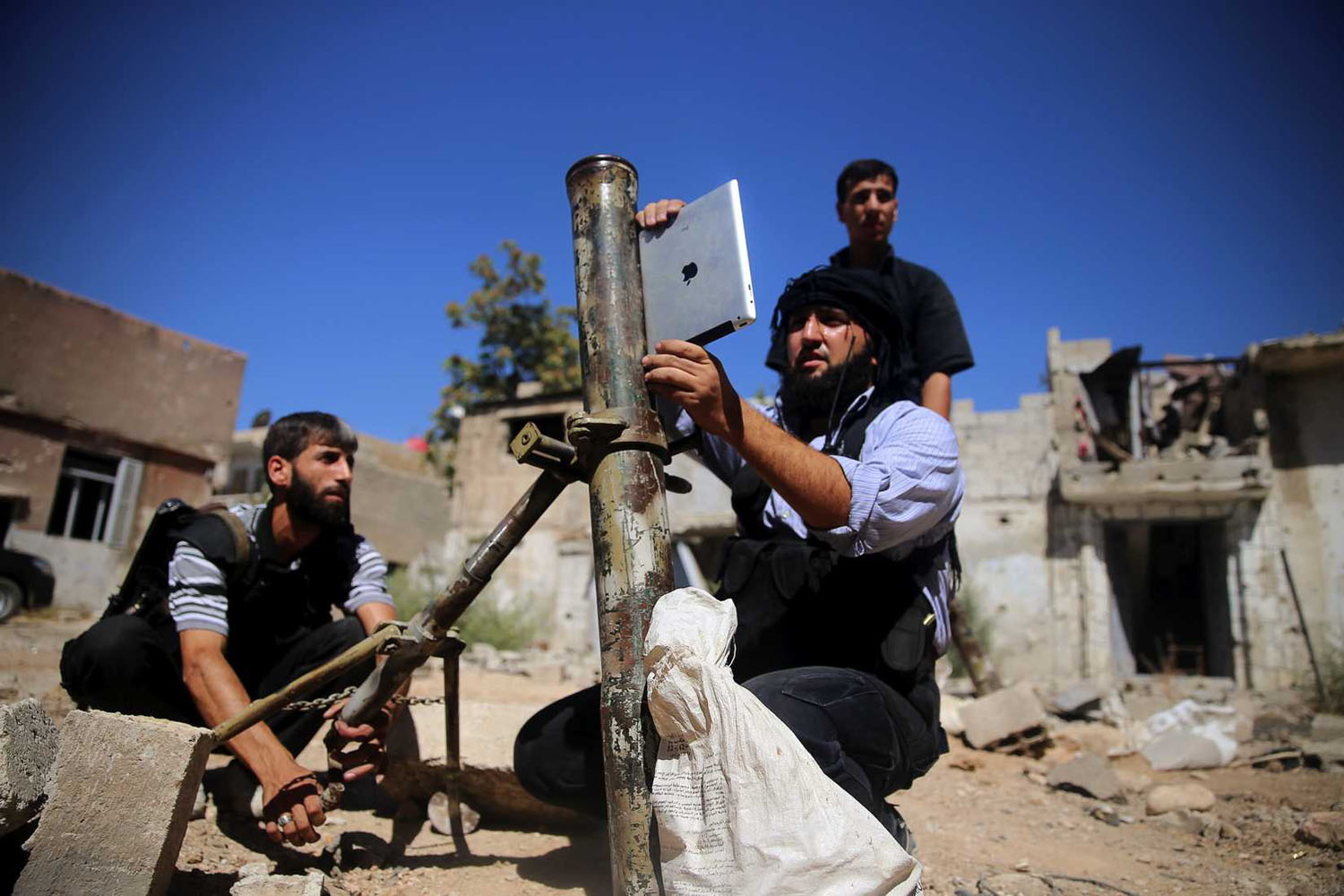 A rebel fighter, who belongs to the Free Syrian Army, uses an iPad during preparations to fire a homemade mortar at a battlefront in Damascus on Sept. 15, 2013
