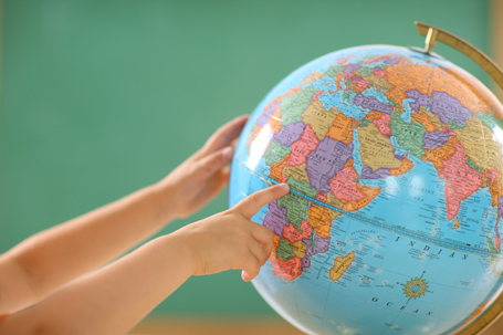 Child looks at school globe