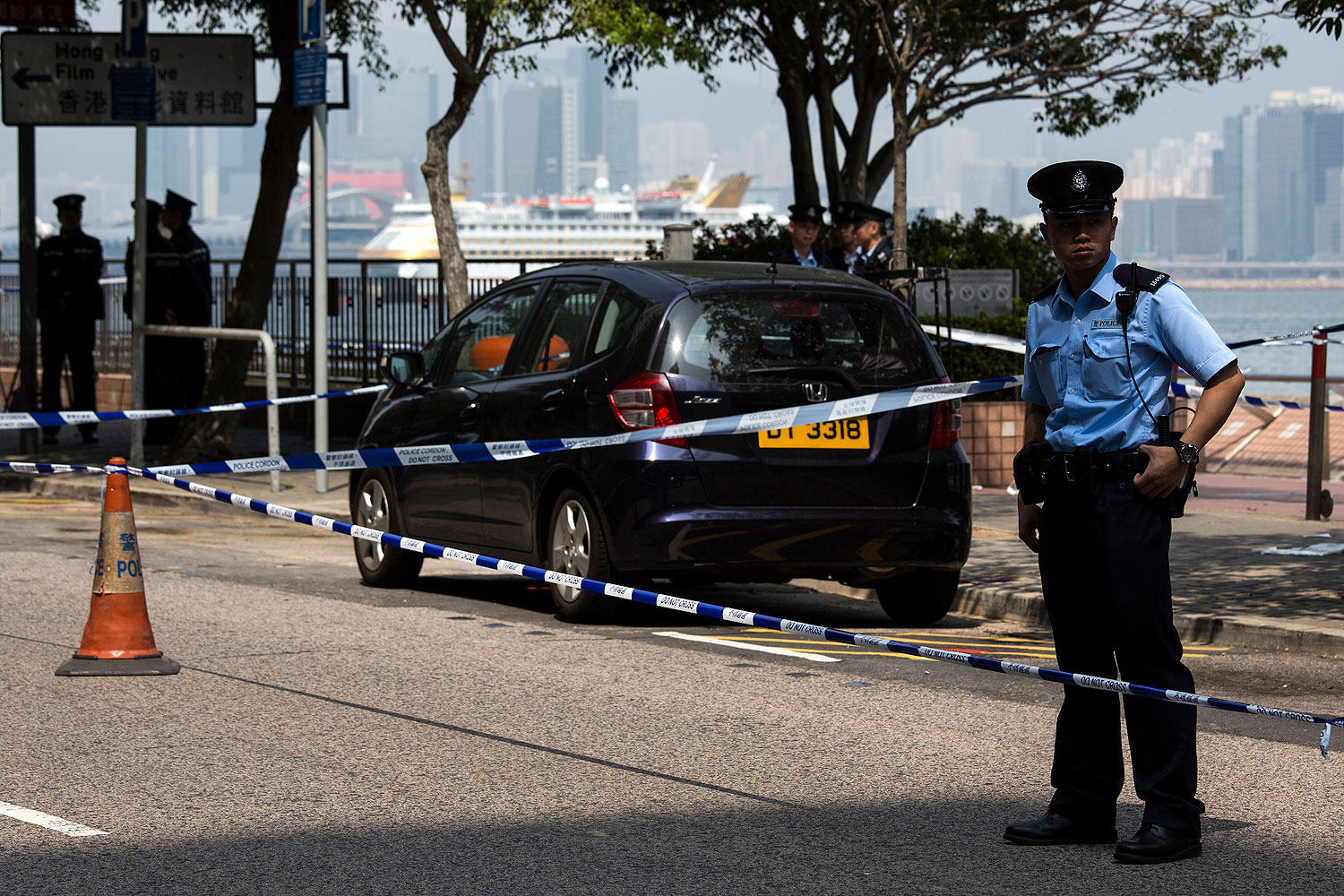 A policeman stands guard next to former Ming Pao chief editor Kevin Lau's car after Lau suffered from a chopper attack in Hong Kong Feb. 26, 2014 (Tyrone Siu / Reuters)