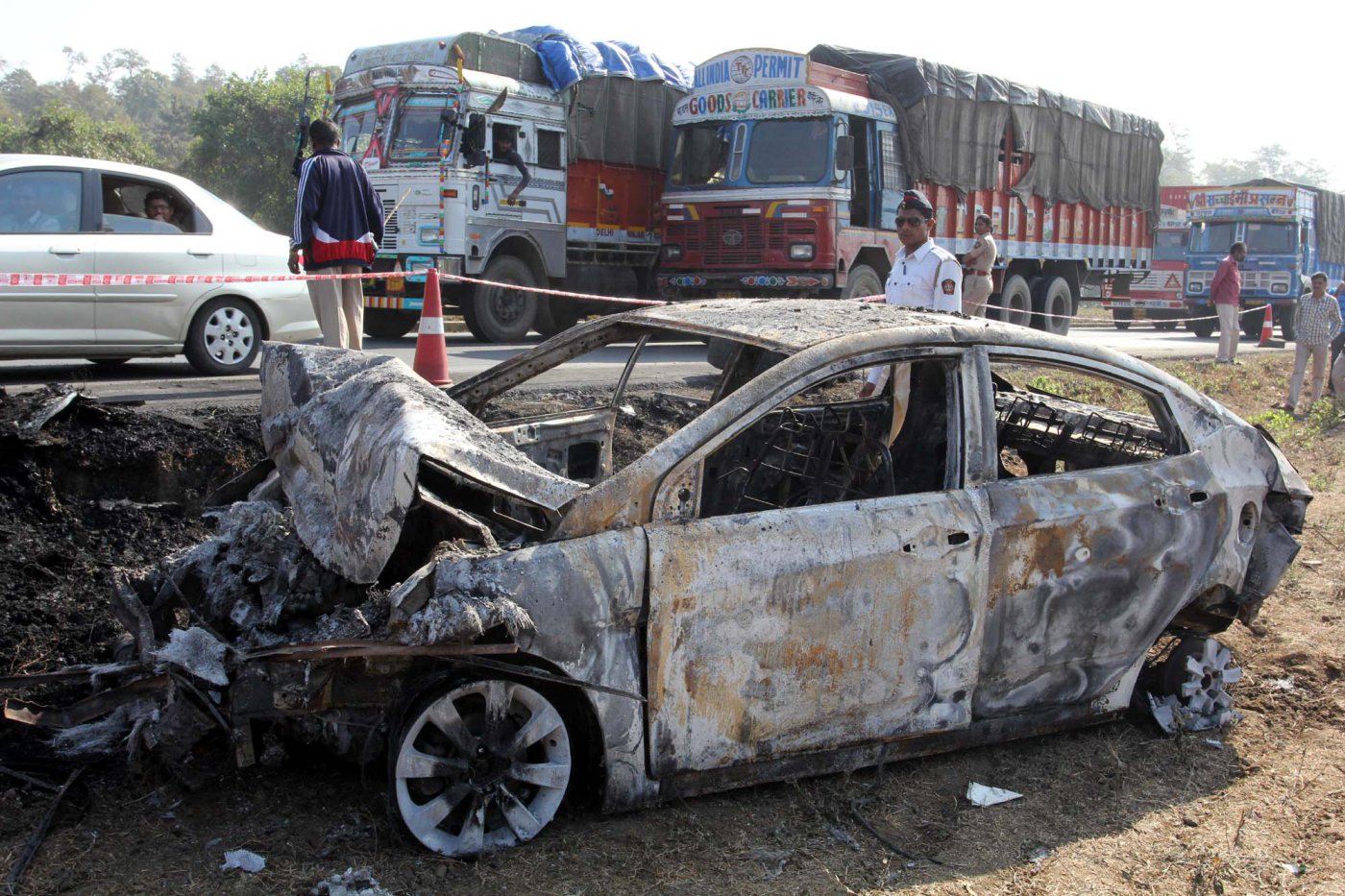 A charred car stands at the accident spot on the Mumbai-Ahmedabad highway near Manor police station following the collision between a tanker containing diesel and a luxury bus on Jan. 29, 2014, in Mumbai, India. (Praful Gangurde—Hindustan Times/Getty Images)