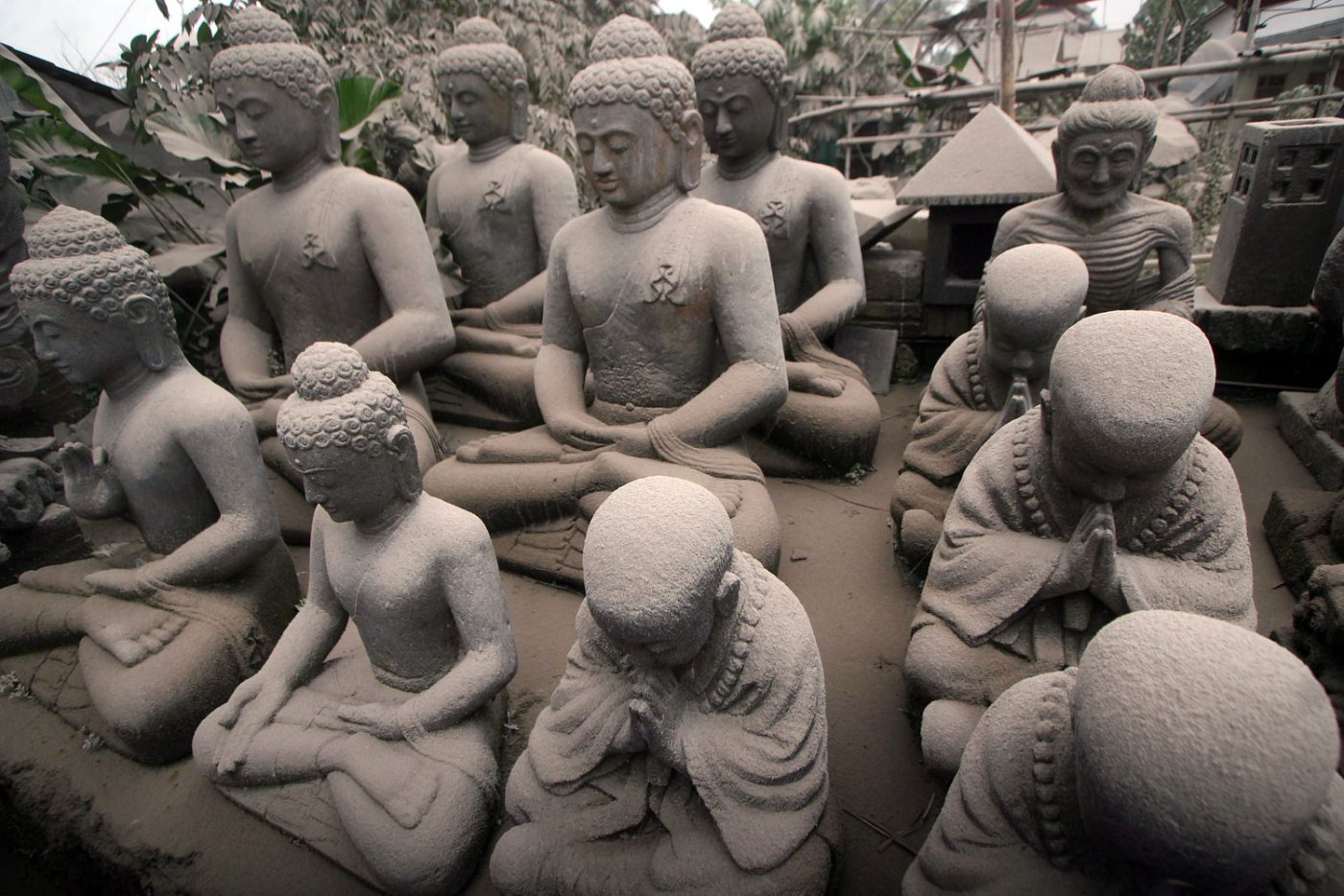 Buddha statues are covered with volcanic ash from the Mount Kelud volcano eruption at a shop in Magelang, Central Java, Feb. 14, 2014.