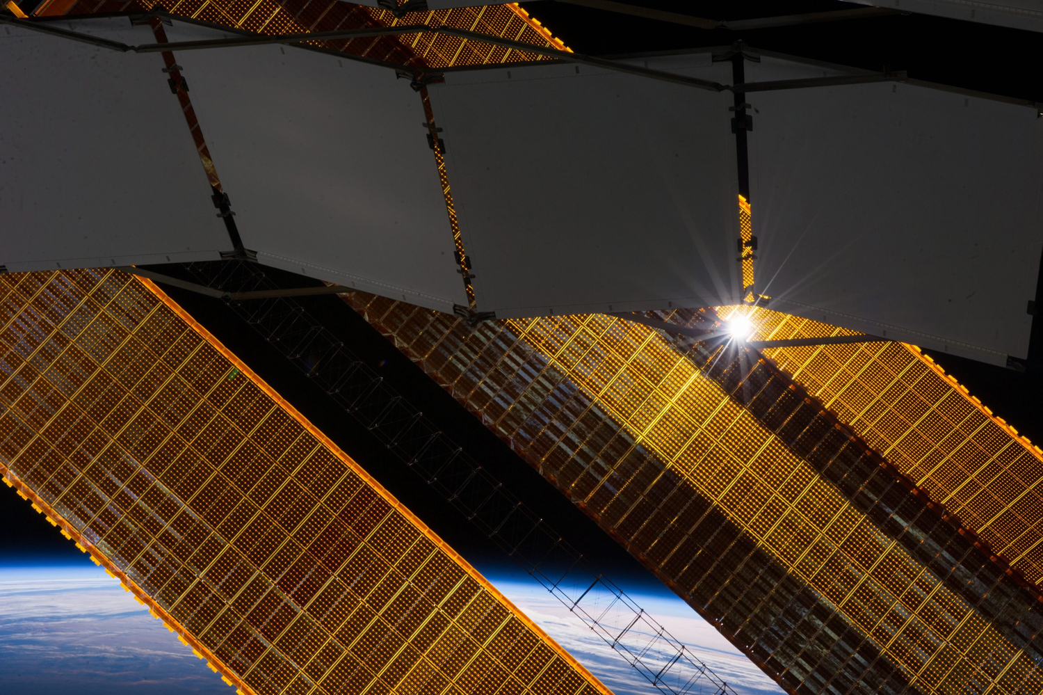 The sun shines through a radiator and a solar array panel on the International Space Station (ISS) in this photograph taken by a crew member on Jan. 2, 2014.