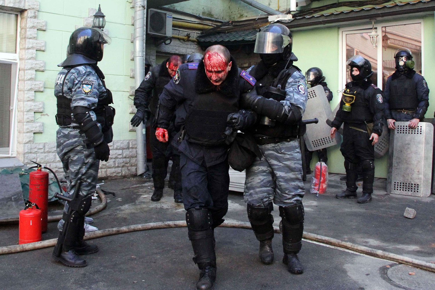 Interior Ministry members injured during clashes with anti-government protesters are escorted by colleagues in Kiev, on Feb. 18, 2014.