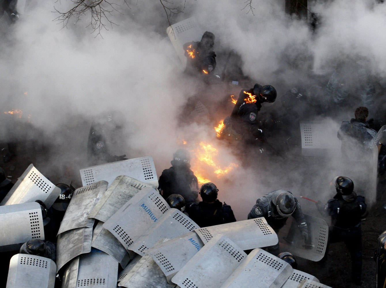 Policemen run amid flames during clashes with anti-government protesters in front of the Ukrainian Parliament in Kiev, on Feb. 18, 2014.