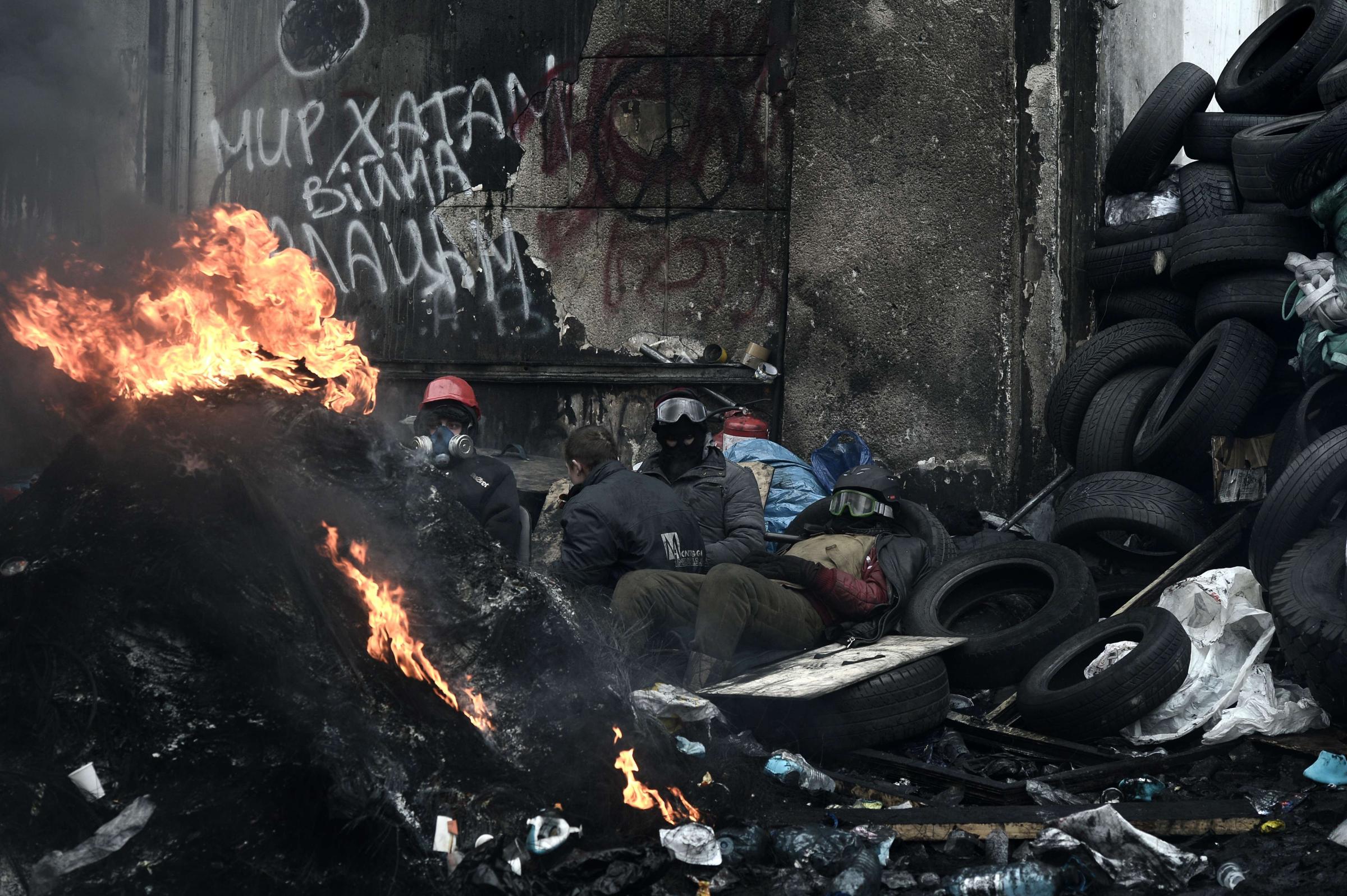 A anti-government protesters rest near a fire next to a road block in Kiev on Jan. 28, 2014.