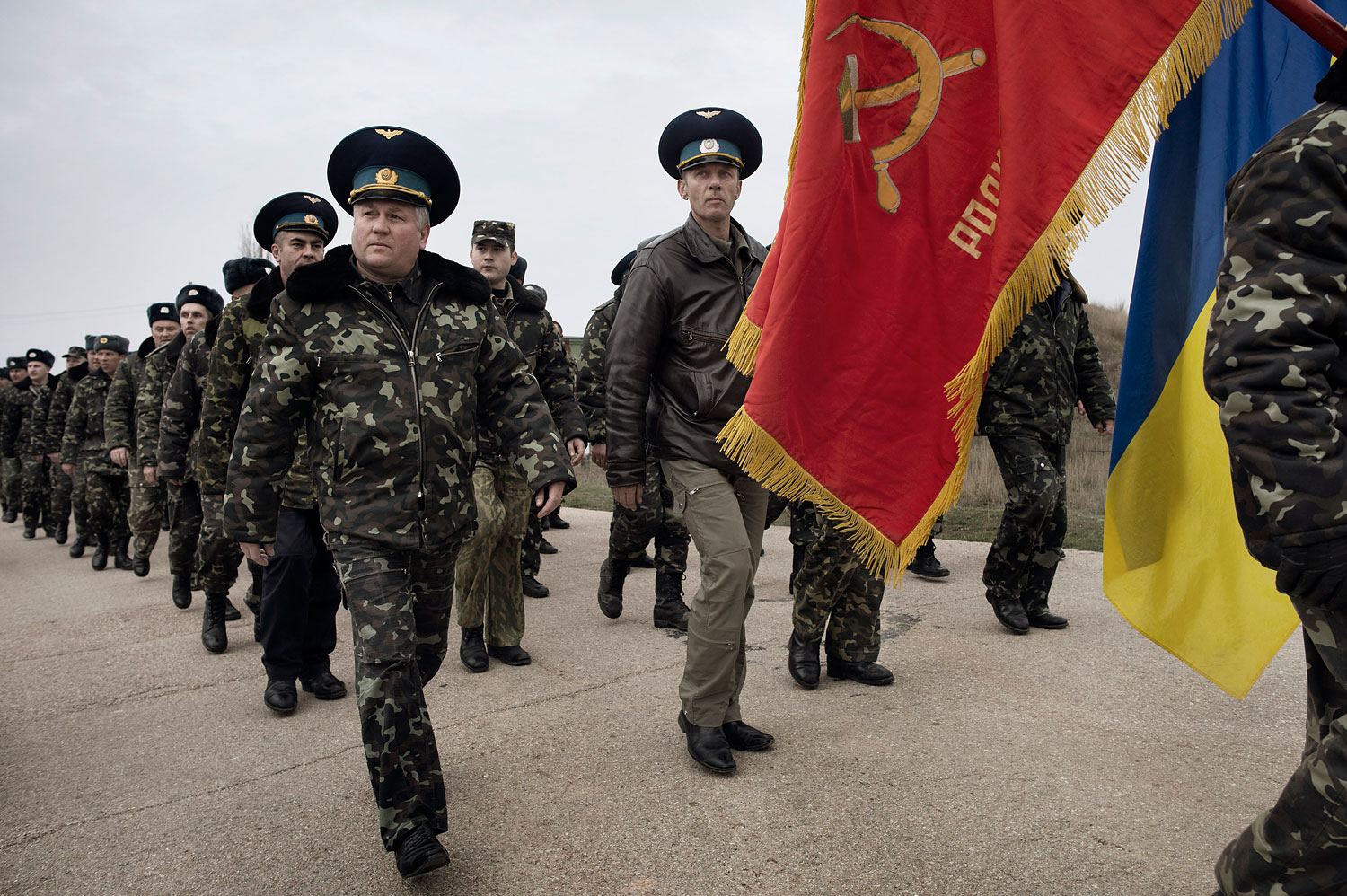 Unarmed Ukrainian soldiers, carrying a Soviet air-regiment banner, approach Russian positions on the perimeter of the contested Belbek air-force base in Crimea, Ukraine, on March 4, 2014.