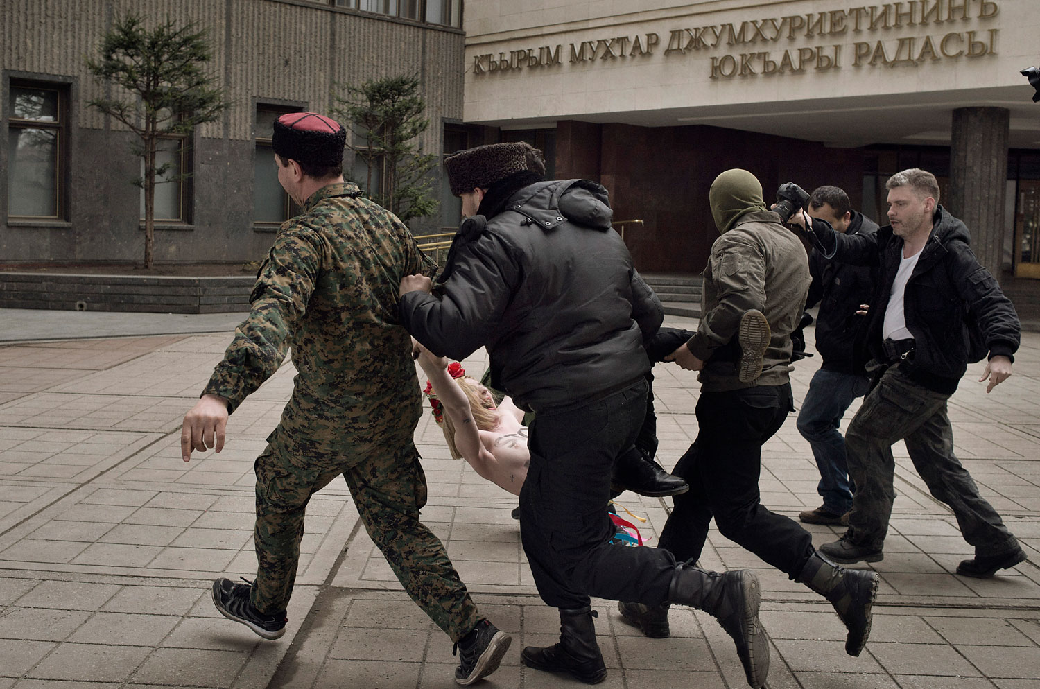 Cossacks and Ukrainian police detain feminist protesters who interrupted a pro-Russian rally with shouts of “Stop Putin’s war” in Simferopol, Crimea, March 6, 2014.