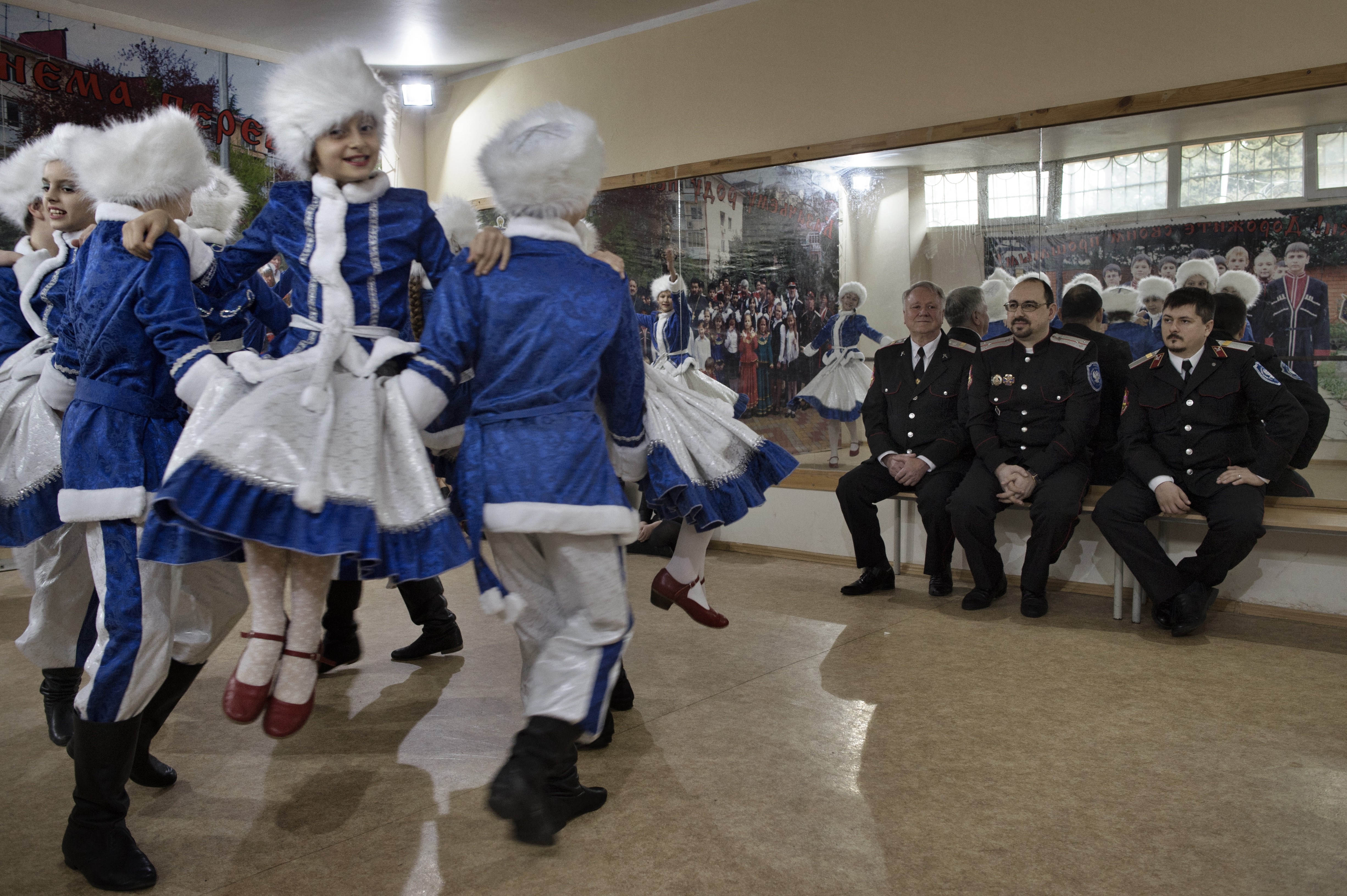 Sochi, Russia, Jan. 14, 2014: Cossack officers watch students perform a traditional Russian dance at School No. 10 in the city of Sochi. The dance classes are part of the Cossack curriculum recently implemented at the school under its director, Vladimir Davydov (pictured center). Davydov, a member of the Sochi city council, is an active member of the local Cossack community.