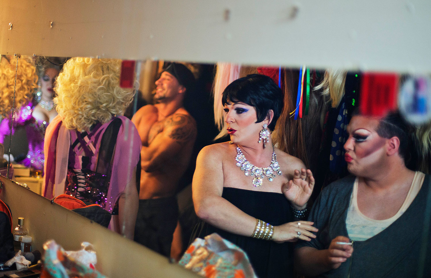 Andrei Sarkisian, second from right, who goes by the stage name of Miss Zhuzha, gets ready backstage before a performance at the Mayak cabaret in Sochi, Feb. 8, 2014.