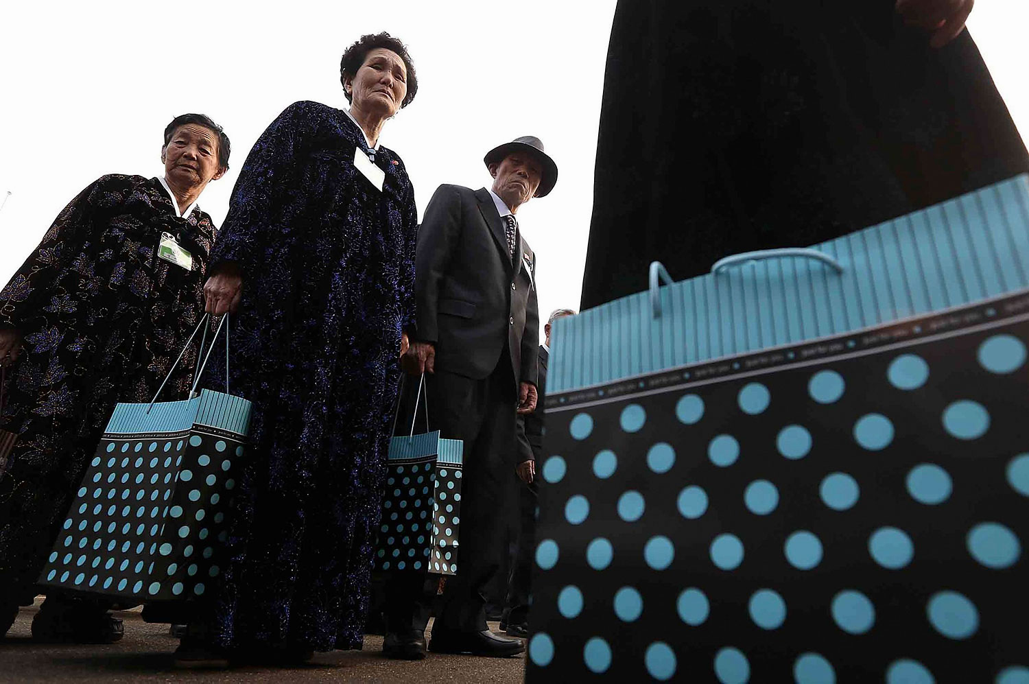 North Koreans carrying bags of presents for their South Korean family members wait in line to attend a luncheon during the Separated Family Reunion Meeting at the Mount Kumgang resort in North Korea, Feb. 24, 2014.