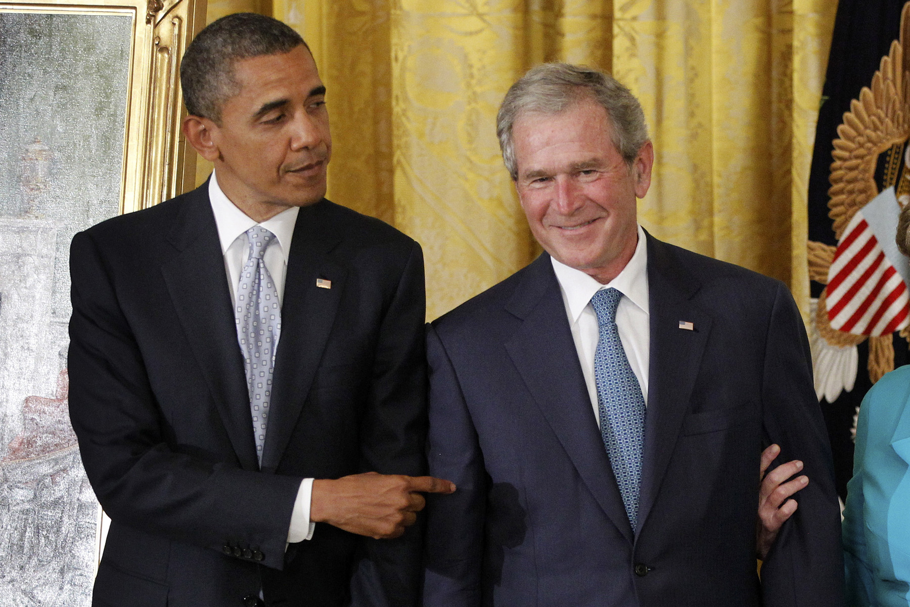 President Barack Obama points to former President George W. Bush during a ceremony to unveil his official portrait, Thursday, May 31, 2012, in the East Room at the White House in Washington. (Charles Dharapa—AP)