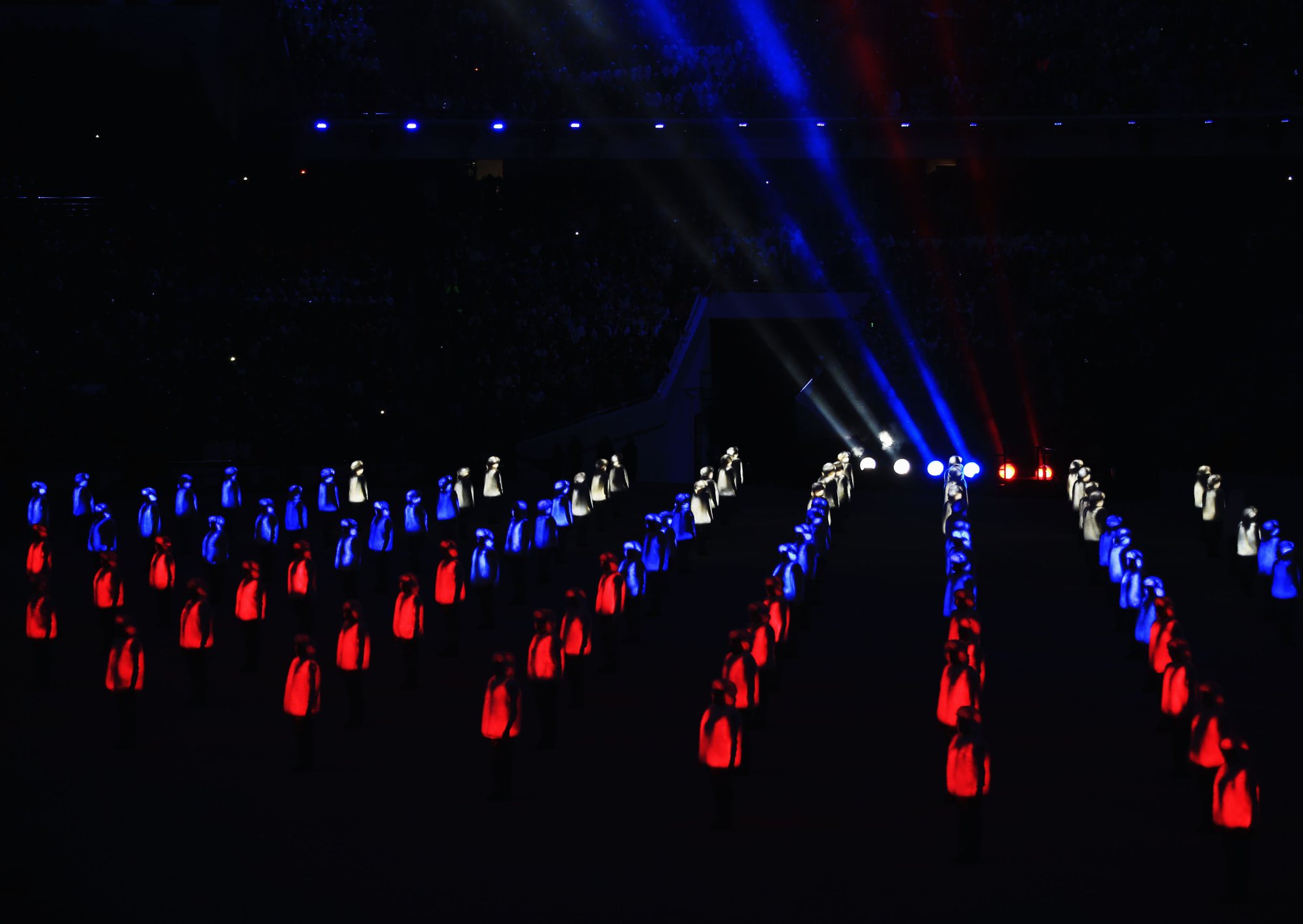 Athlete marshals light up to form a Russian flag.