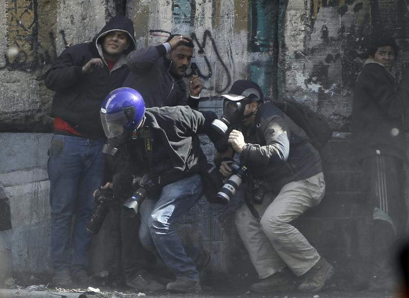 Photographers cower as protesters throw stones towards riot police along Sheikh Rihan street near Tahrir Square in Cairo January 25, 2013. (Amr Dalsh—Reuters)