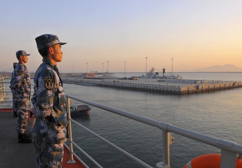 Chinese naval soldiers stand guard on China's first aircraft carrier Liaoning, as it travels towards a military base in Sanya