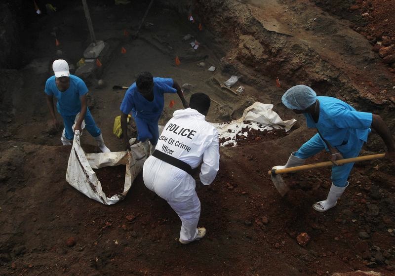 Police officers and doctors dig up skeletons at a construction site in the former war zone in Mannar