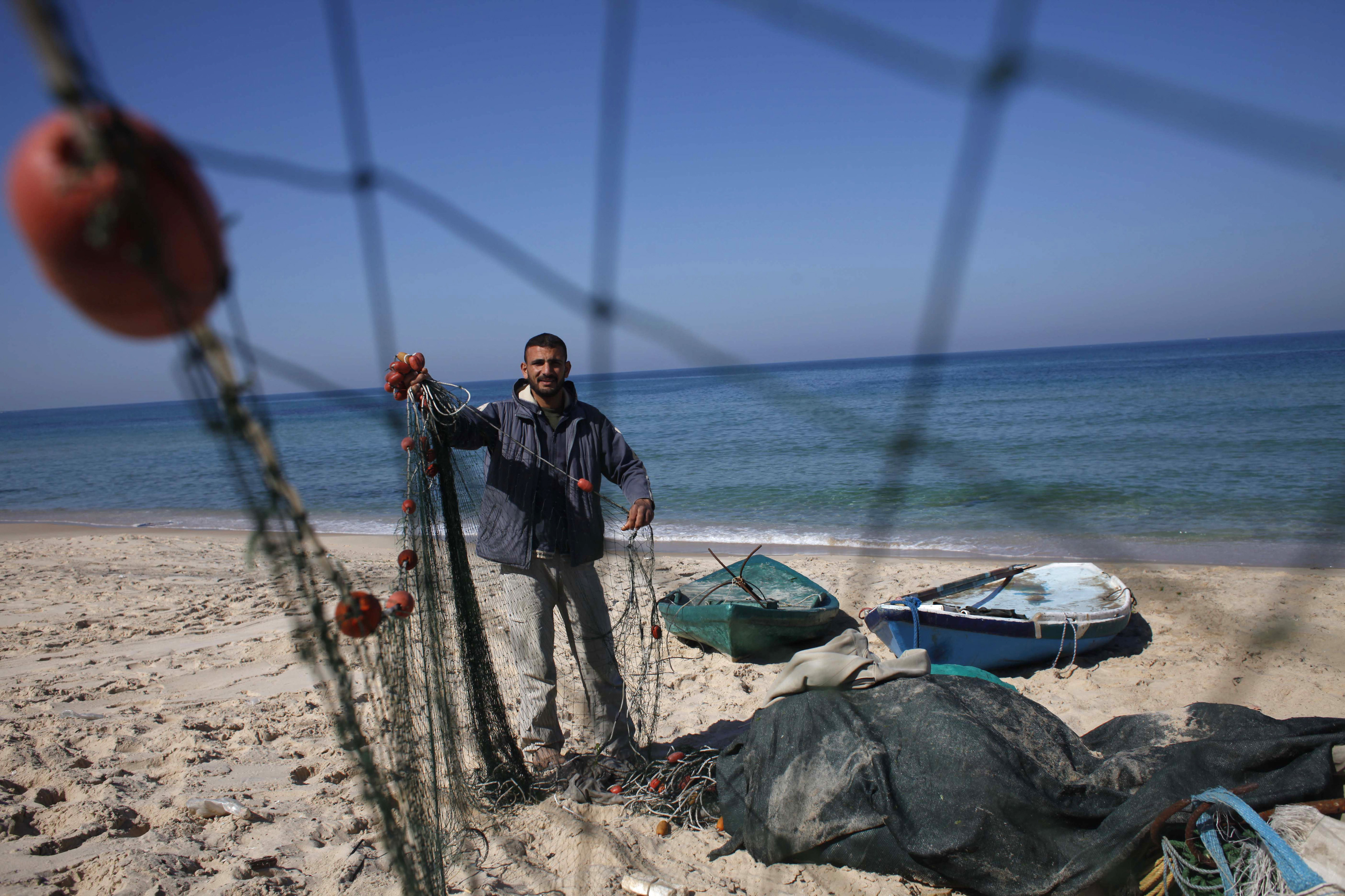 Palestinian fisherman Joudat Ghrab, who said he scooped a 500-kg bronze statue of the Greek God Apollo from the sea bed last August, prepares his fishing net on the beach of Deir El-Balah in the central Gaza Strip February 9, 2014. (Ibraheem Abu Mustafa&mdash;REUTERS)
