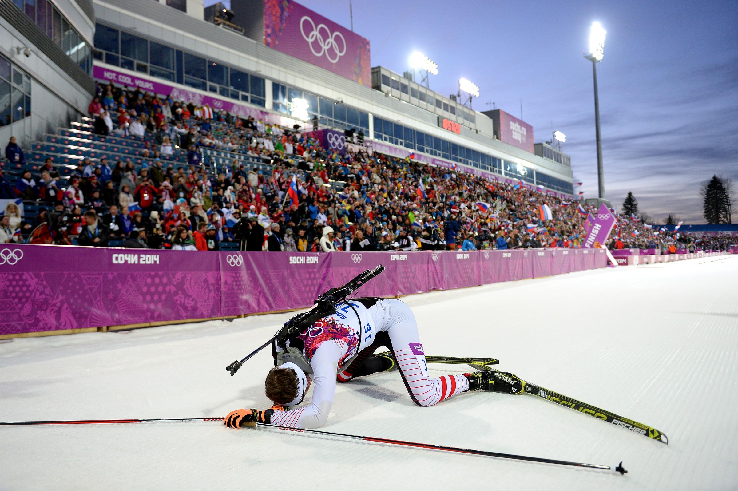 Simon Eder of Austria collapses in the snow after the Men's Individual 20 km.