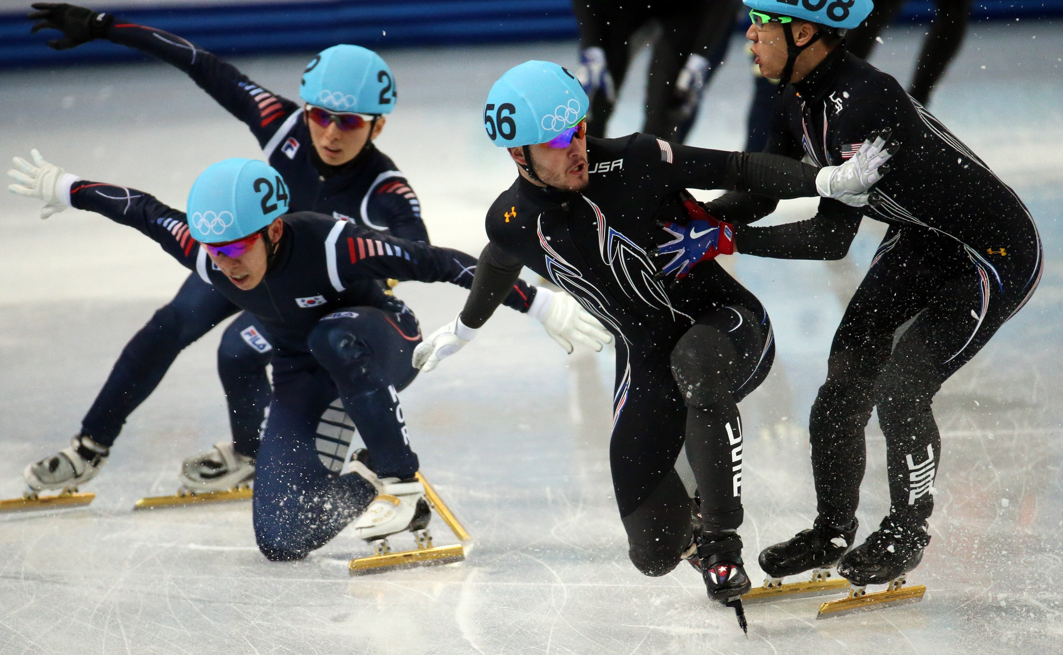 USA's J.R. Celski (258) tries to pick up teammate Eduardo Alvarez (256) after a collision with the Korean team in a semifinal of the men's 5000m short track speed skating relay.