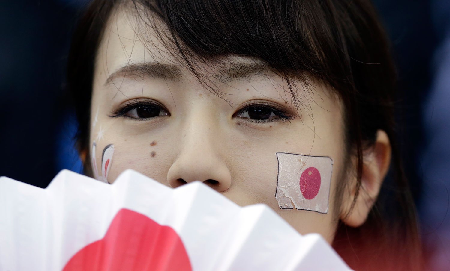 A Japanese fan watches the men's 500-meter speedskating race at the Adler Arena Skating Center at the 2014 Winter Olympics, Feb. 10, 2014, in Sochi.