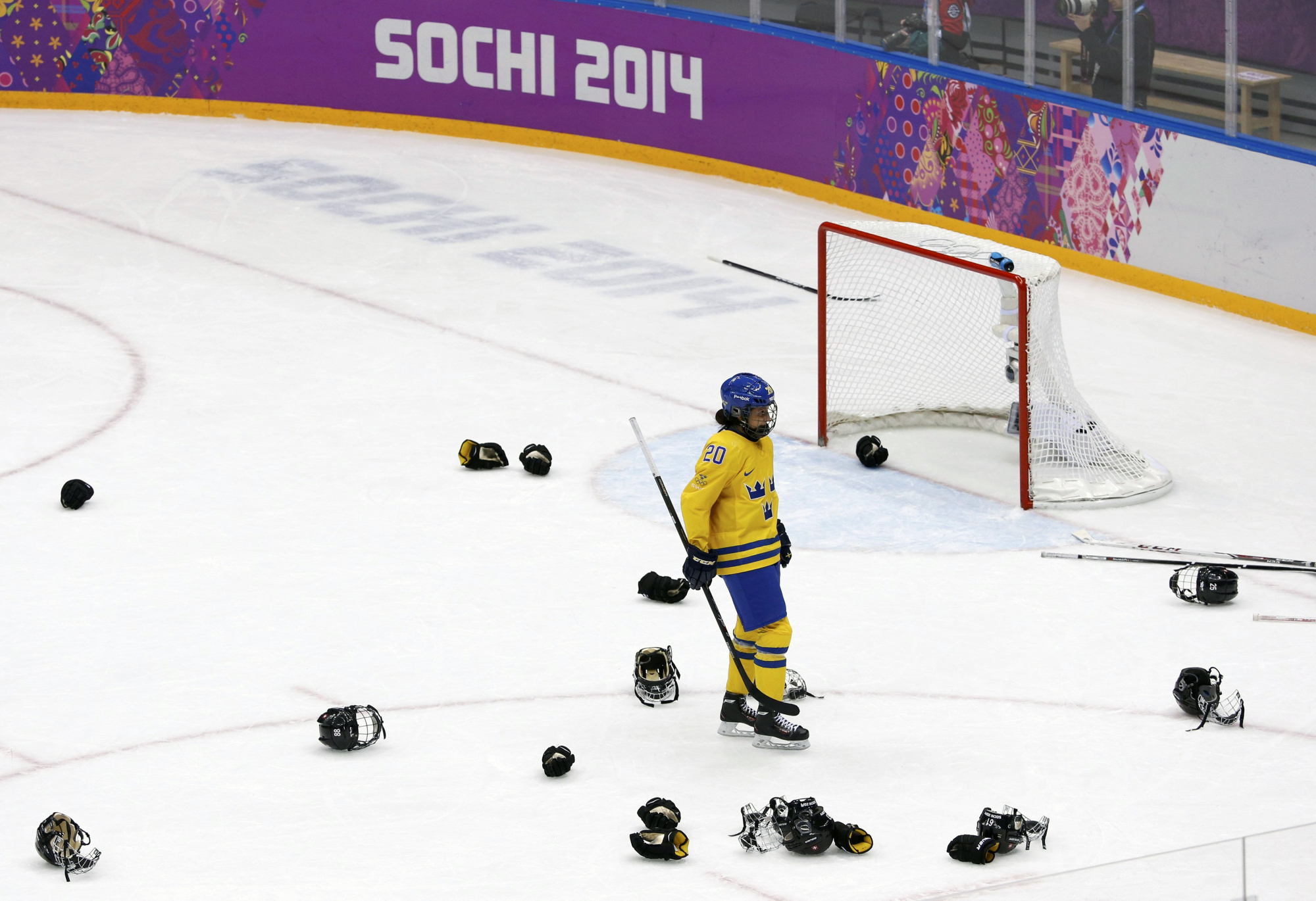 Sweden's Fanny Rask skates through the helmets and gloves of Switzerland's celebrating players at the end of their women's ice hockey bronze medal game.
