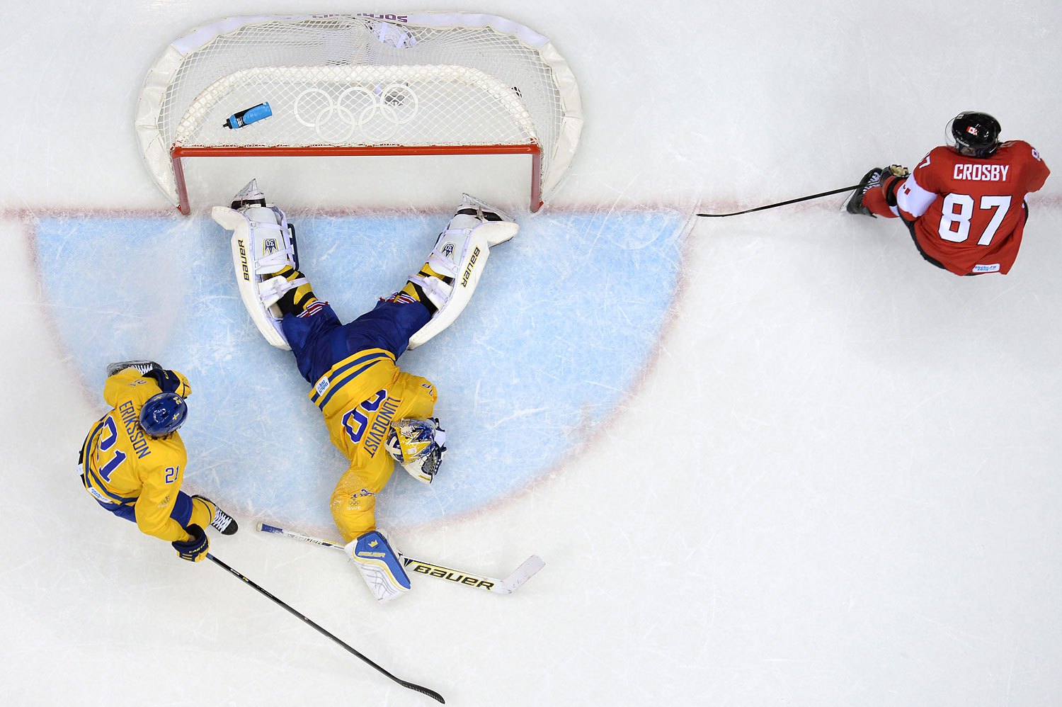 Canada's Sidney Crosby (R) scores in the nets of Sweden's goalkeeper Henrik Lundqvist as Sweden's Loui Eriksson looks on during the Men's ice hockey final Sweden vs Canada.