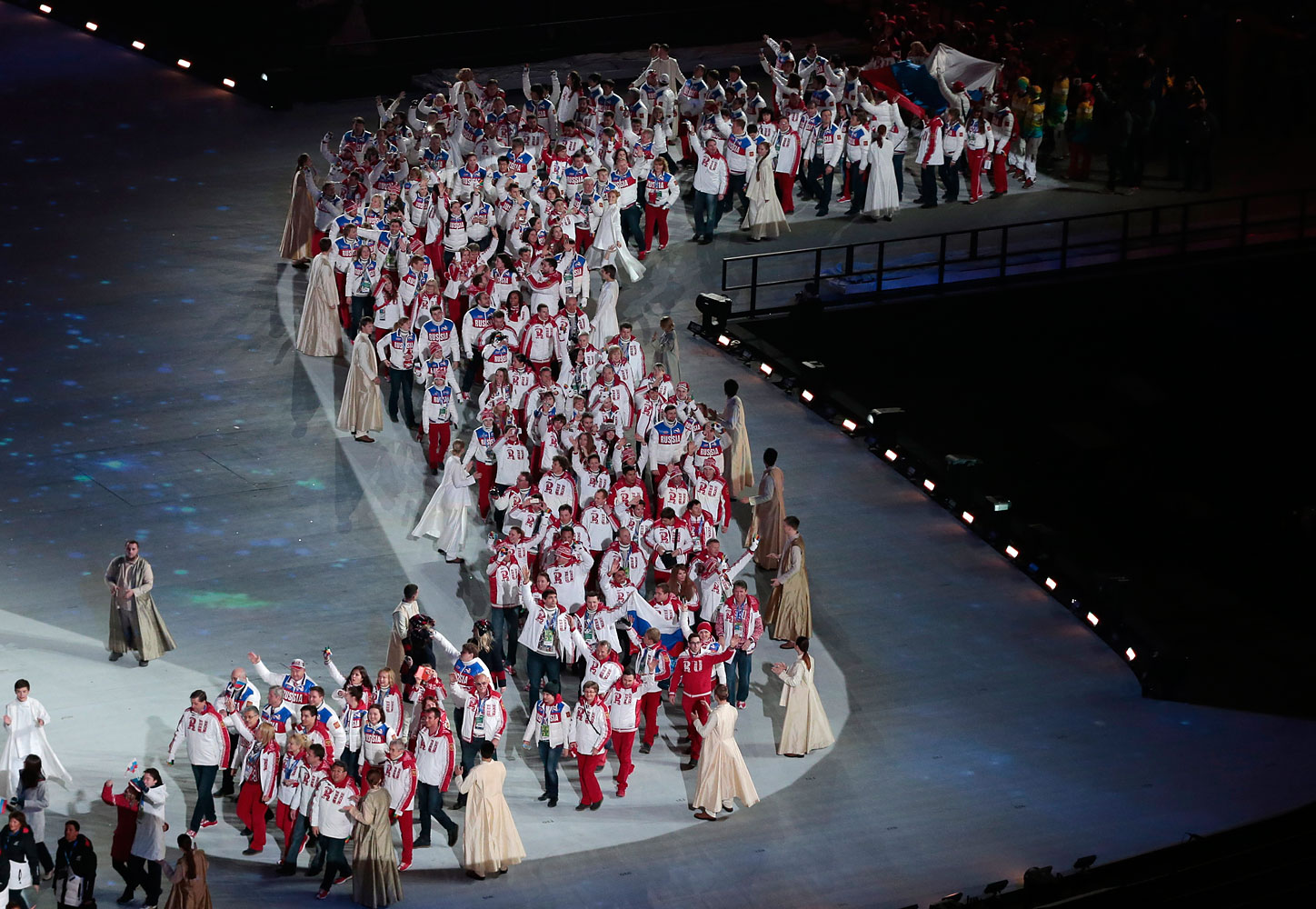 Members of the Russian Olympic team walk on stage.