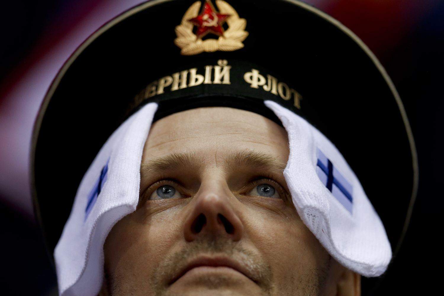 A hockey fan wears symbols from the Finnish flag before a men's ice hockey game against Canada at the 2014 Winter Olympics, Sunday, Feb. 16, 2014, in Sochi, Russia.