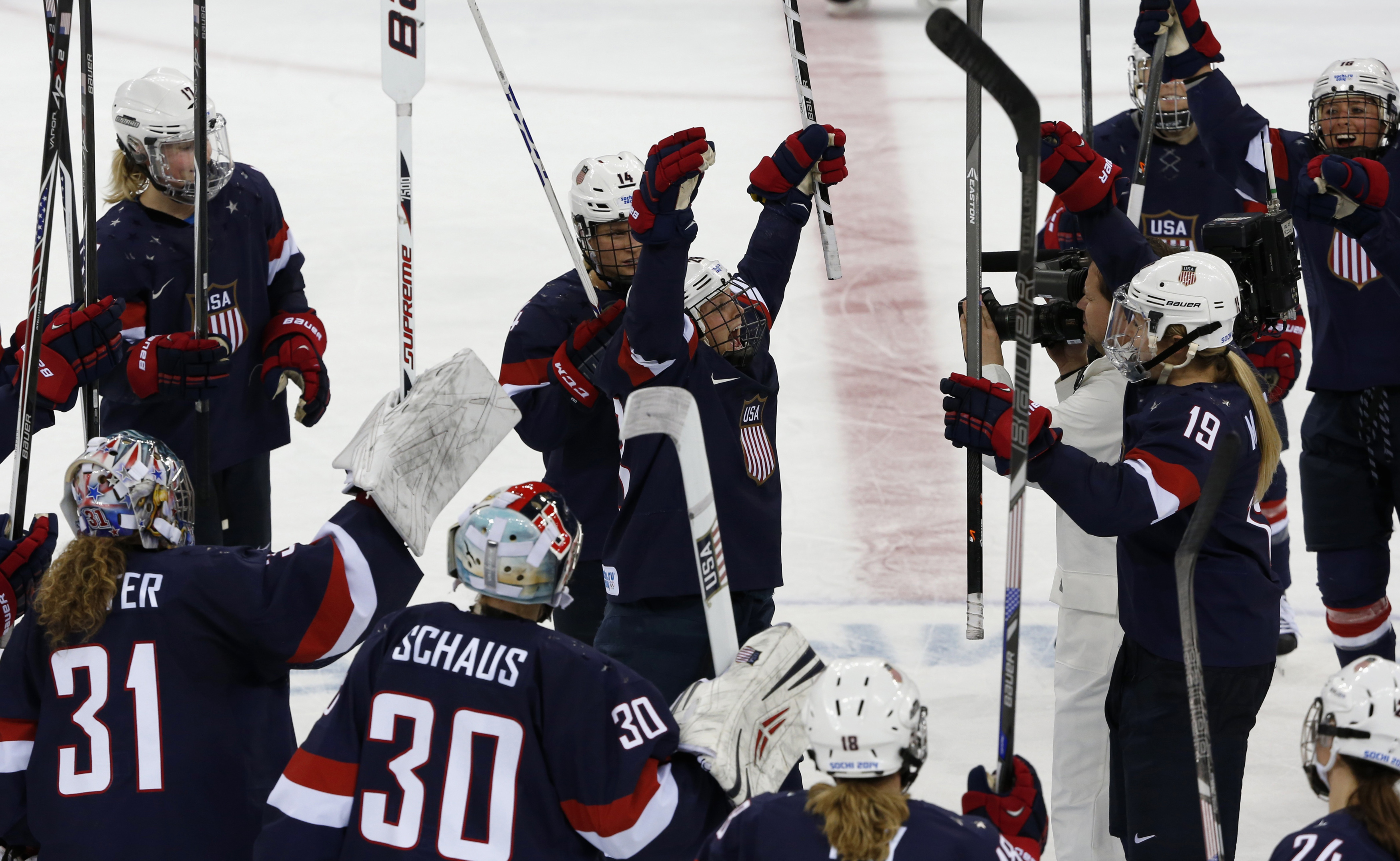 Team USA players celebrate their win over Sweden in their women's ice hockey semi-final game at the Sochi 2014 Winter Olympic Games Feb. 17, 2014.