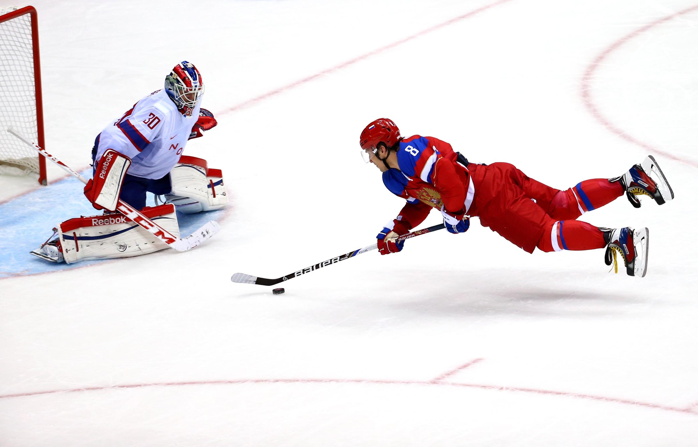 Alexander Ovechkin #8 of Russia falls to the ice against Lars Haugen #30 of Norway during the Men's Ice Hockey Qualification Playoff game.