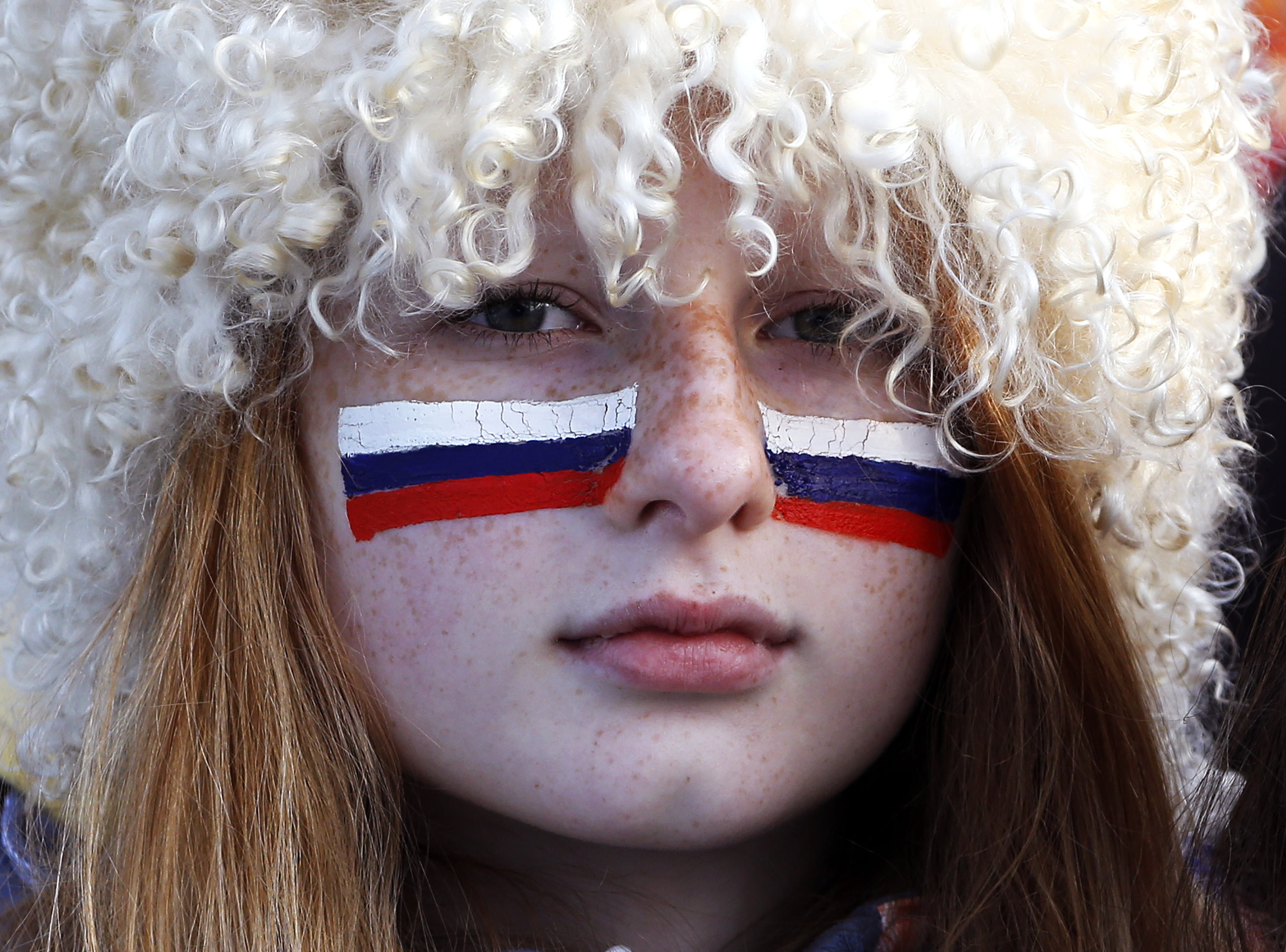 A Russian fan with her face painted with the Russian flag watches the men's quarter-finals ice hockey game between Russia and Finland. Russia was eliminated from the men's ice hockey competition at the Sochi Games on Wednesday following a 3-1 quarter-final loss to Finland. (Eric Gaillard&mdash;Reuters)