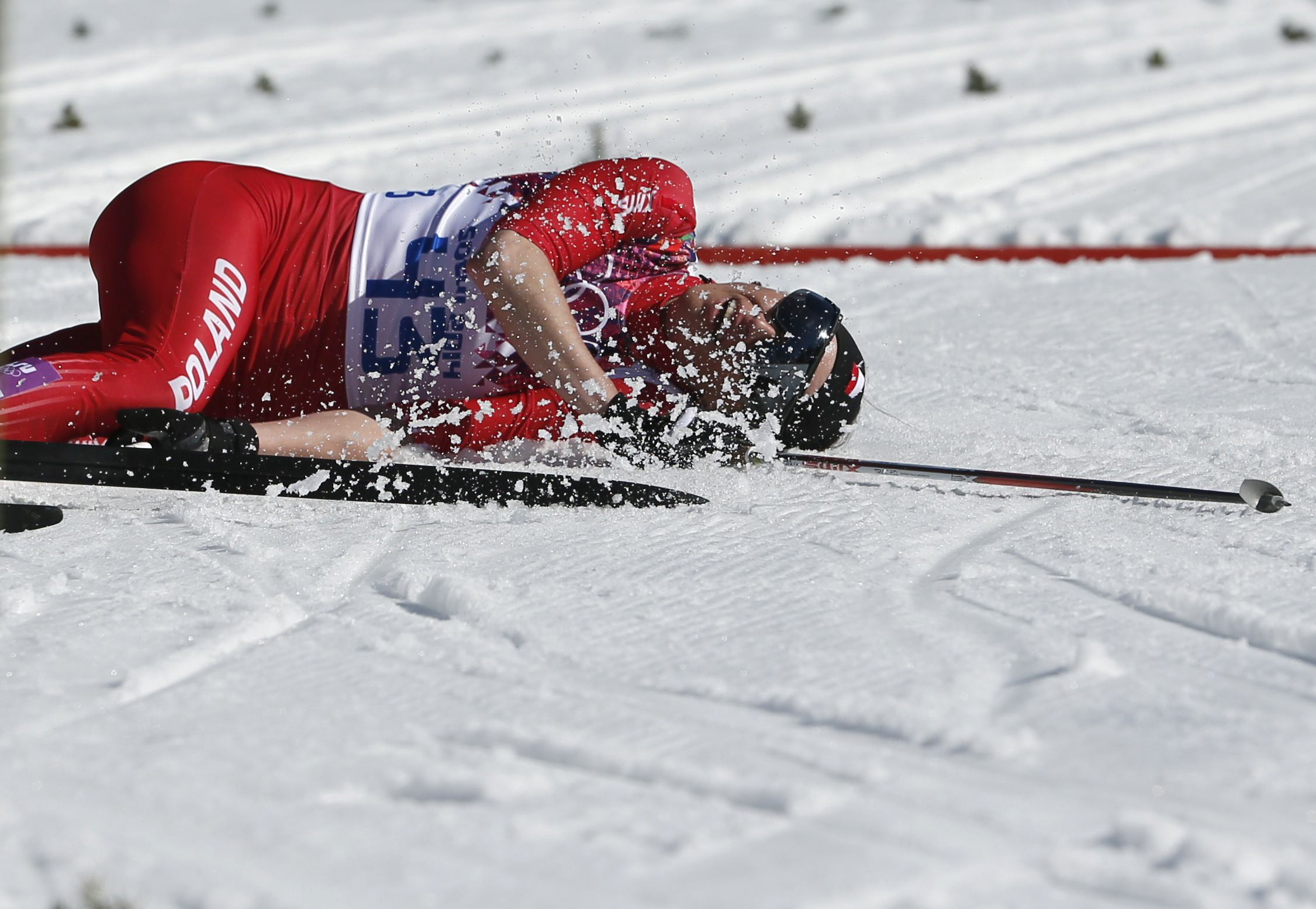 Poland's Justyna Kowalczyk lies on the ground after crossing the finish line in the women's cross-country 10km classic event.