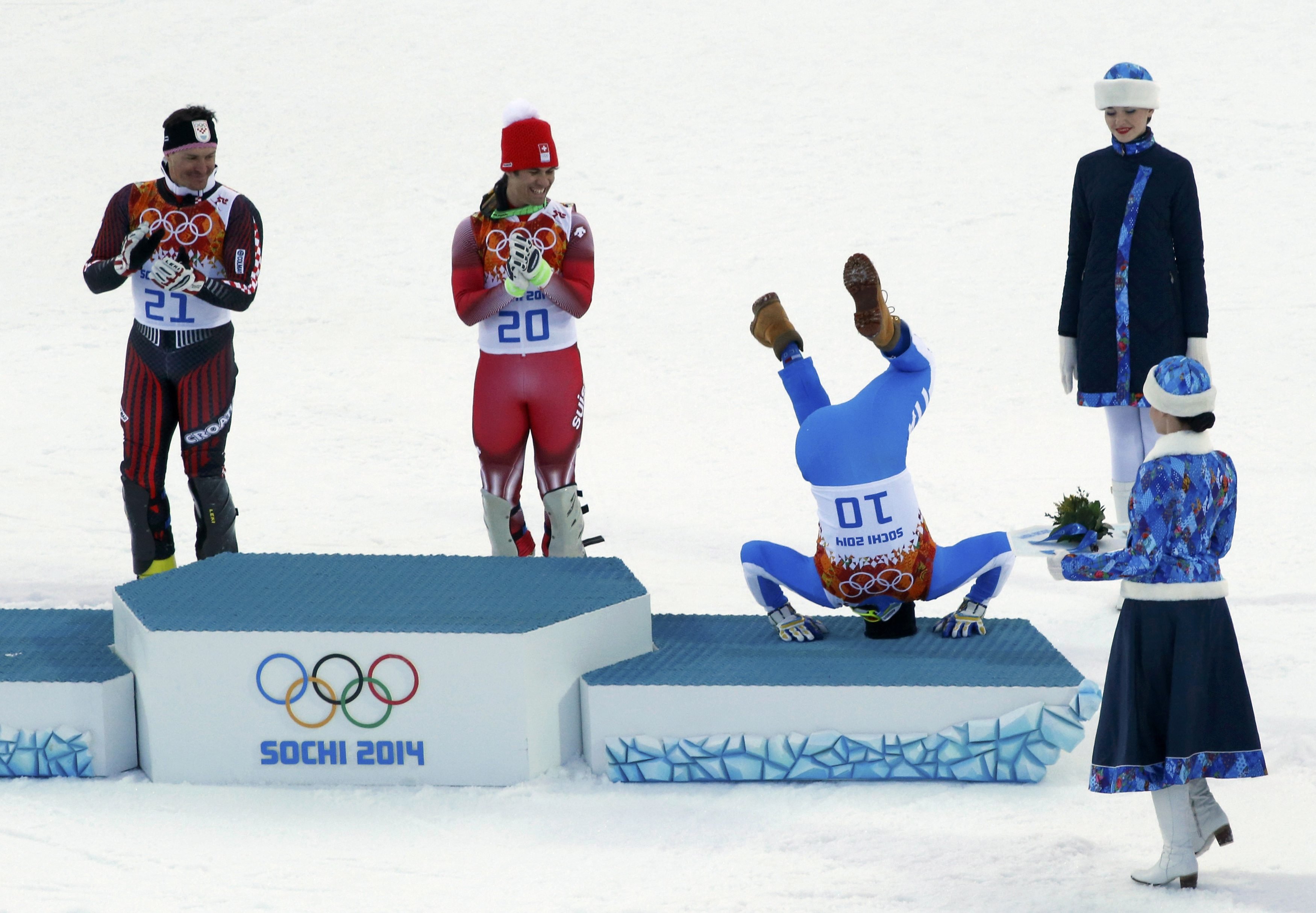 Third-placed Italy's Christof Innerhofer (2nd R) does a somersault on the podium as winner Switzerland's Sandro Viletta (2nd L) and second-placed Croatia's Ivica Kostelic (L) laugh after the men's alpine skiing super combined event.