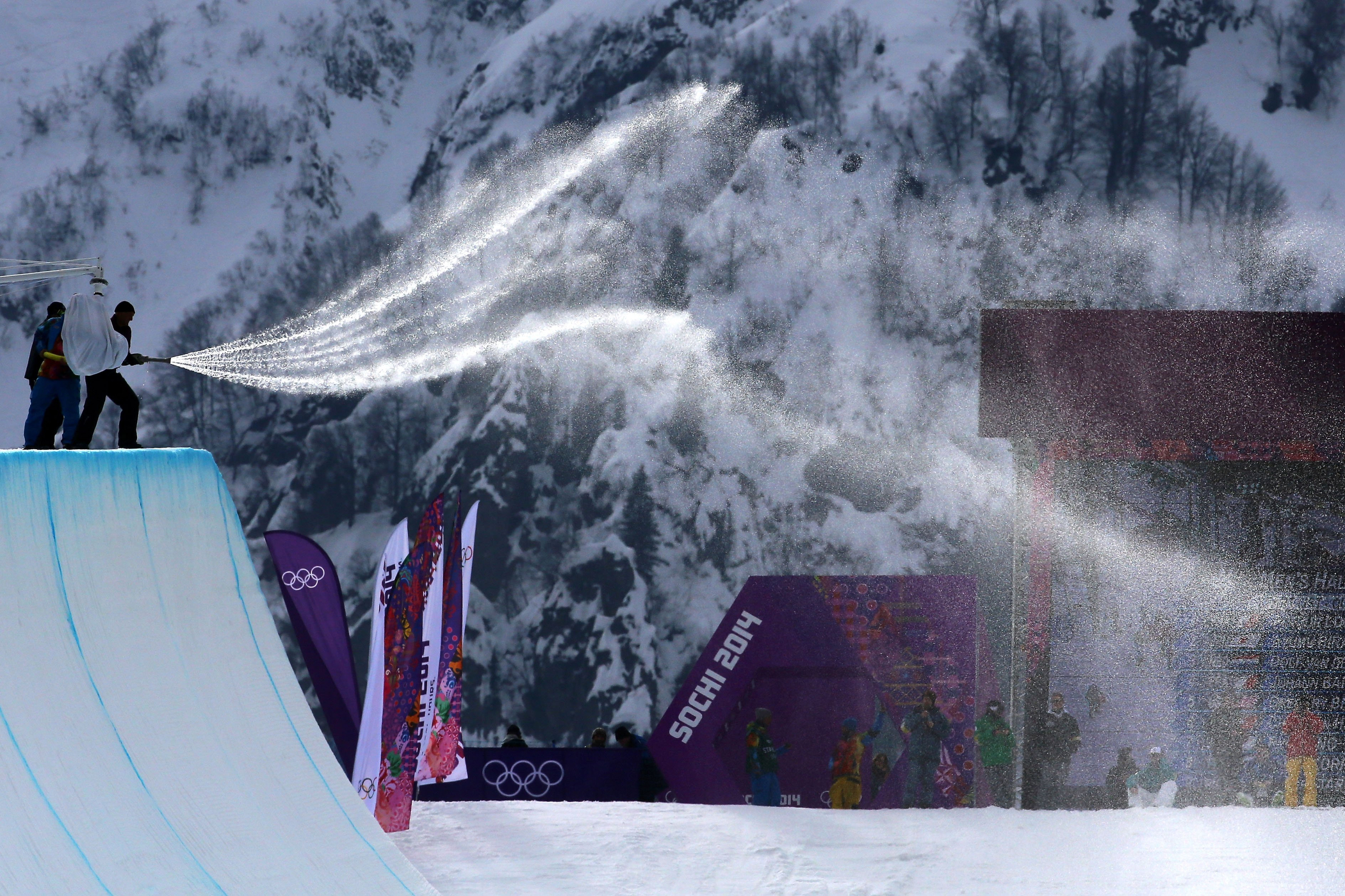Workers spray down the halfpipe before competition begins in the Snowboard Men's Halfpipe Qualification Heats on day four of the Sochi 2014 Winter Olympics at Rosa Khutor Extreme Park on Feb. 11, 2014 in Sochi, Russia.